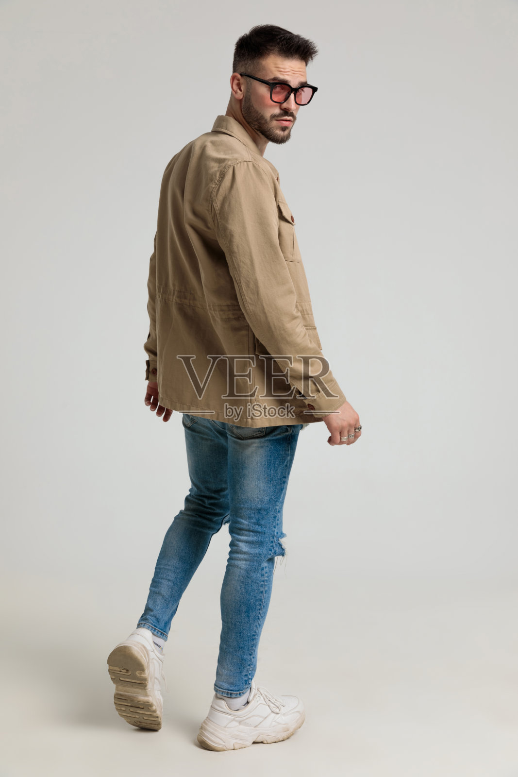 酷年轻的时尚模特在夹克戴着太阳镜和摆姿势照片摄影图片