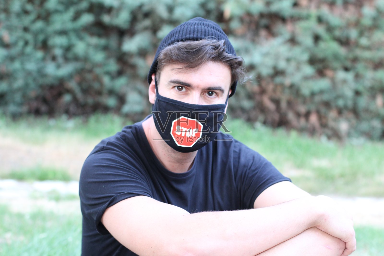 年轻男子戴着防护面罩和停车标志照片摄影图片