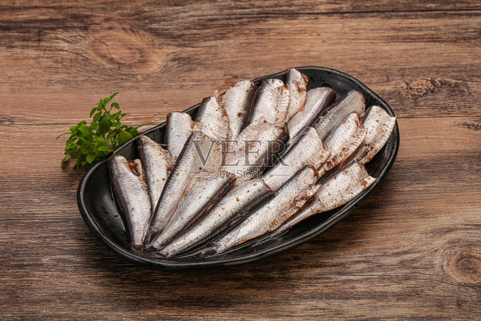 罗勒叶盛在碗里的凤尾鱼照片摄影图片