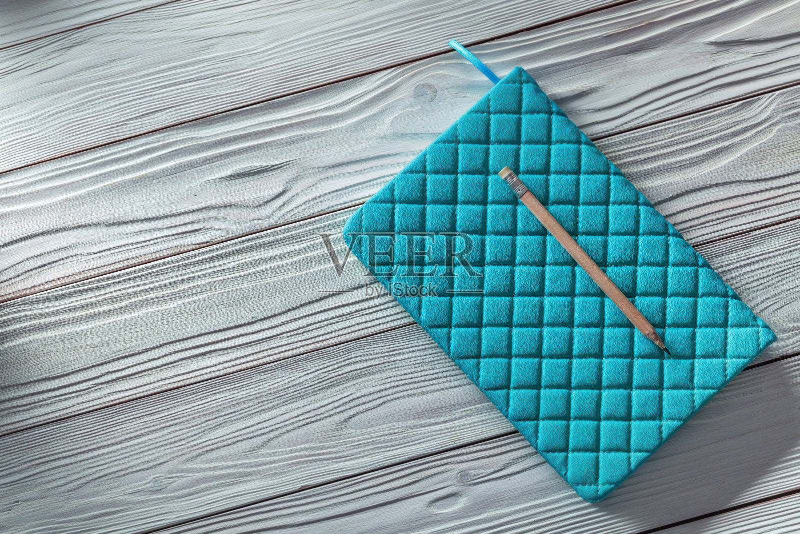 蓝色记事本和经典的铅笔在白色老式木板上照片摄影图片