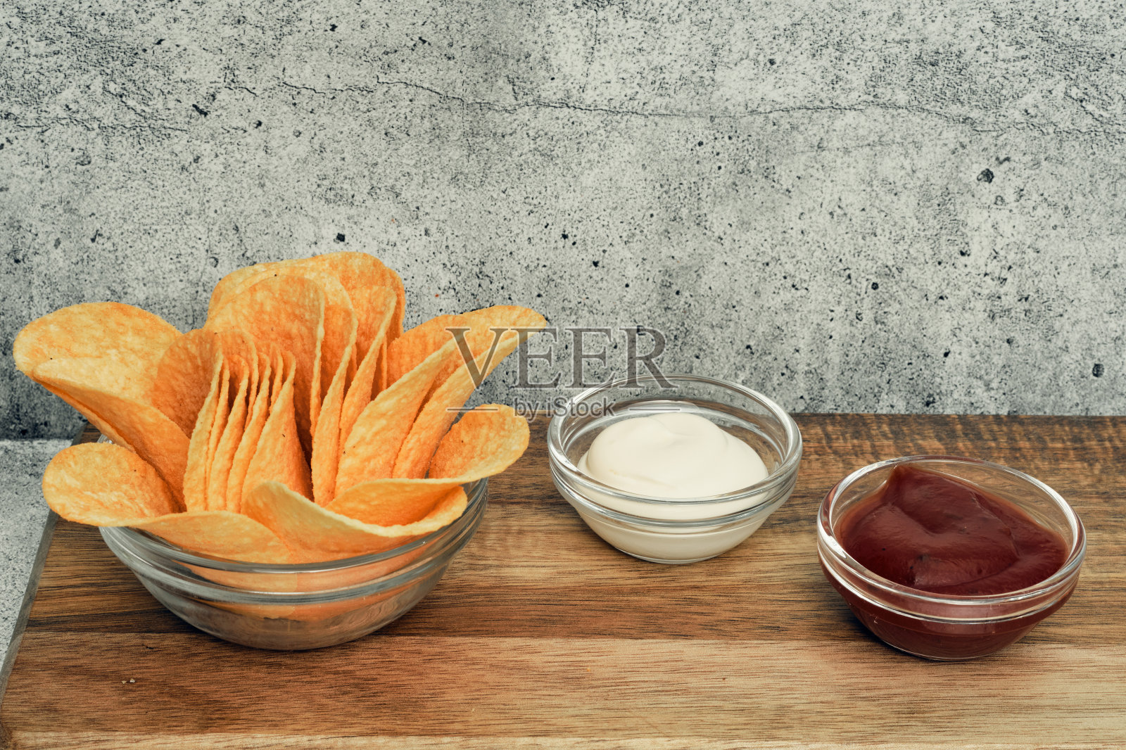 木架上放着土豆片和酱汁。菜单上的即食食品。不健康食品和啤酒小吃。照片摄影图片