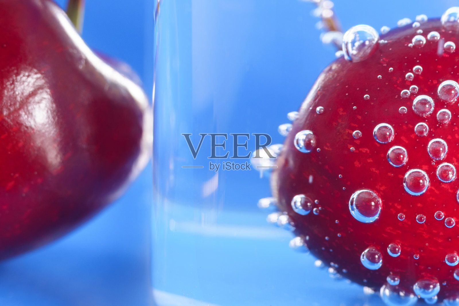 樱桃飞溅在水上。特写,宏。用于新鲜饮料的广告。广告的鸡尾酒。多汁的水果。健康的产品推广形式。照片摄影图片