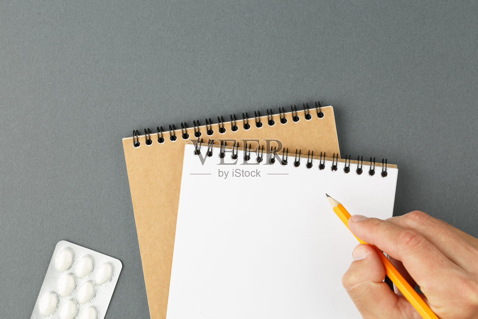 笔记本水泡和男性的手用铅笔。照片摄影图片