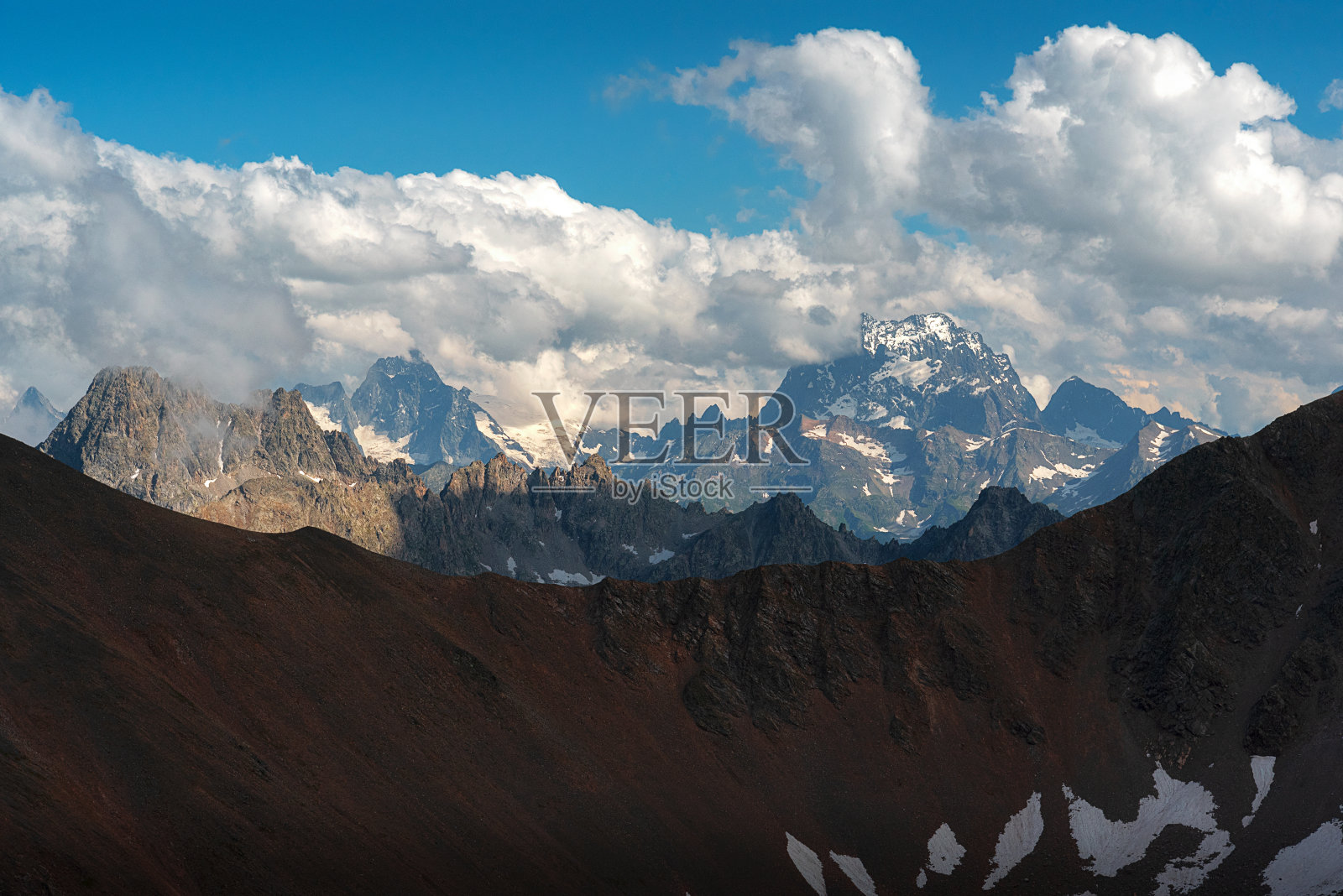 连绵的山脉映衬着云雾缭绕的山坡照片摄影图片