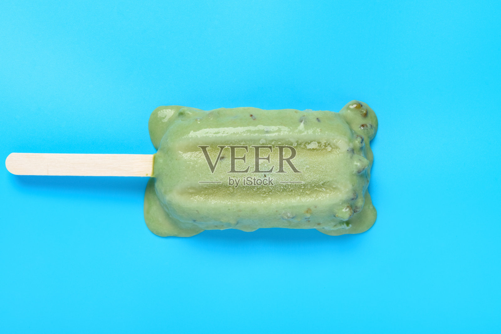 俯视图绿豆冰棒开始融化在一个蓝色的背景照片摄影图片