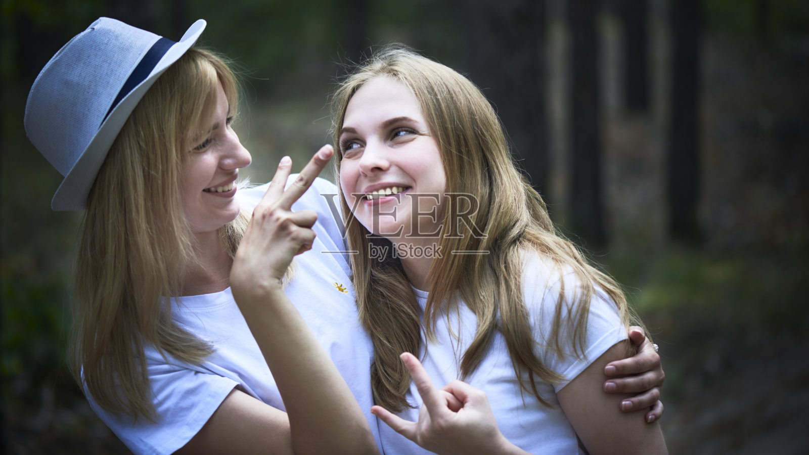 两个年轻女人的肖像,微笑,和平和号角照片摄影图片