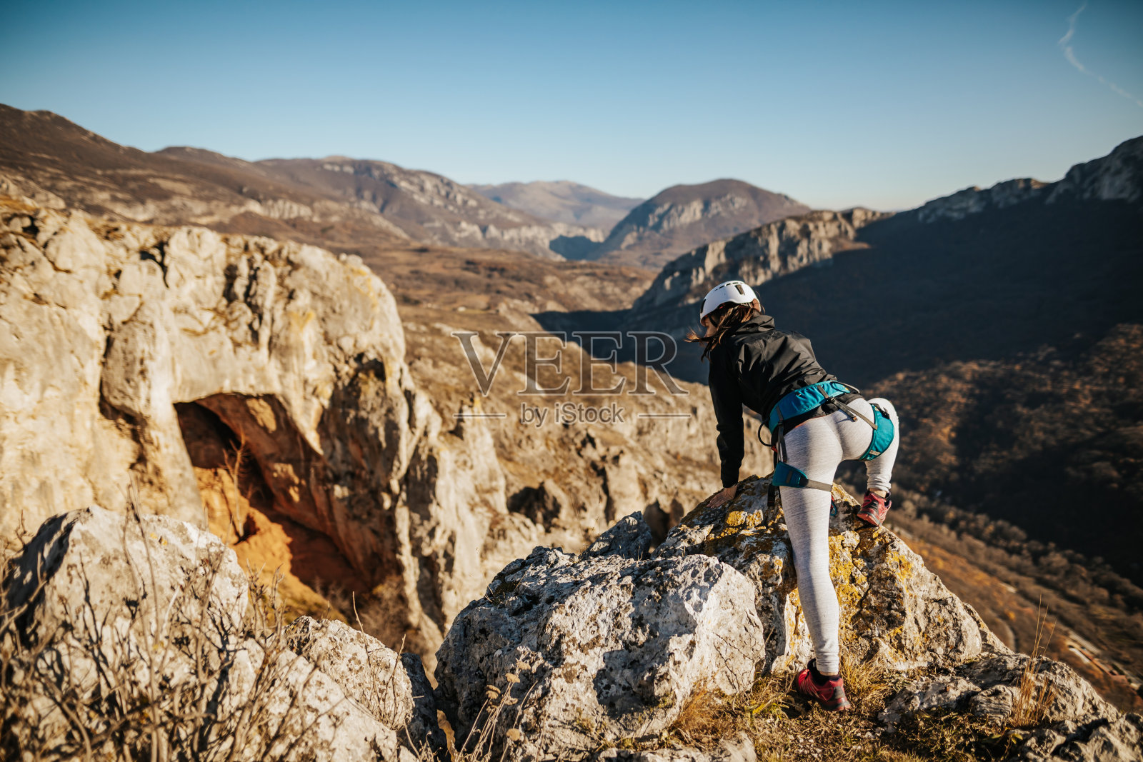 在阳光明媚的秋日,徒步者爬向山顶照片摄影图片