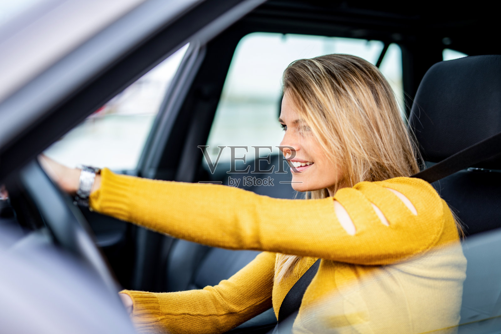 一个快乐的年轻女人在开车。照片摄影图片