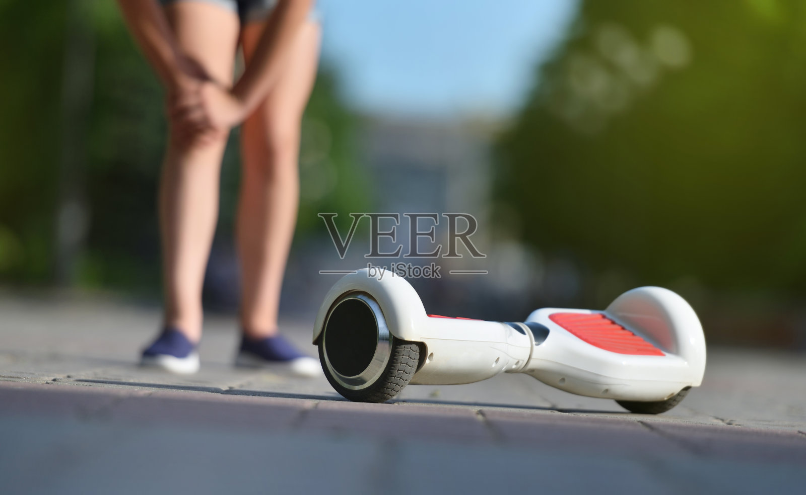 一个小女孩在公园里骑车时从悬浮滑板上摔下来伤了膝盖照片摄影图片