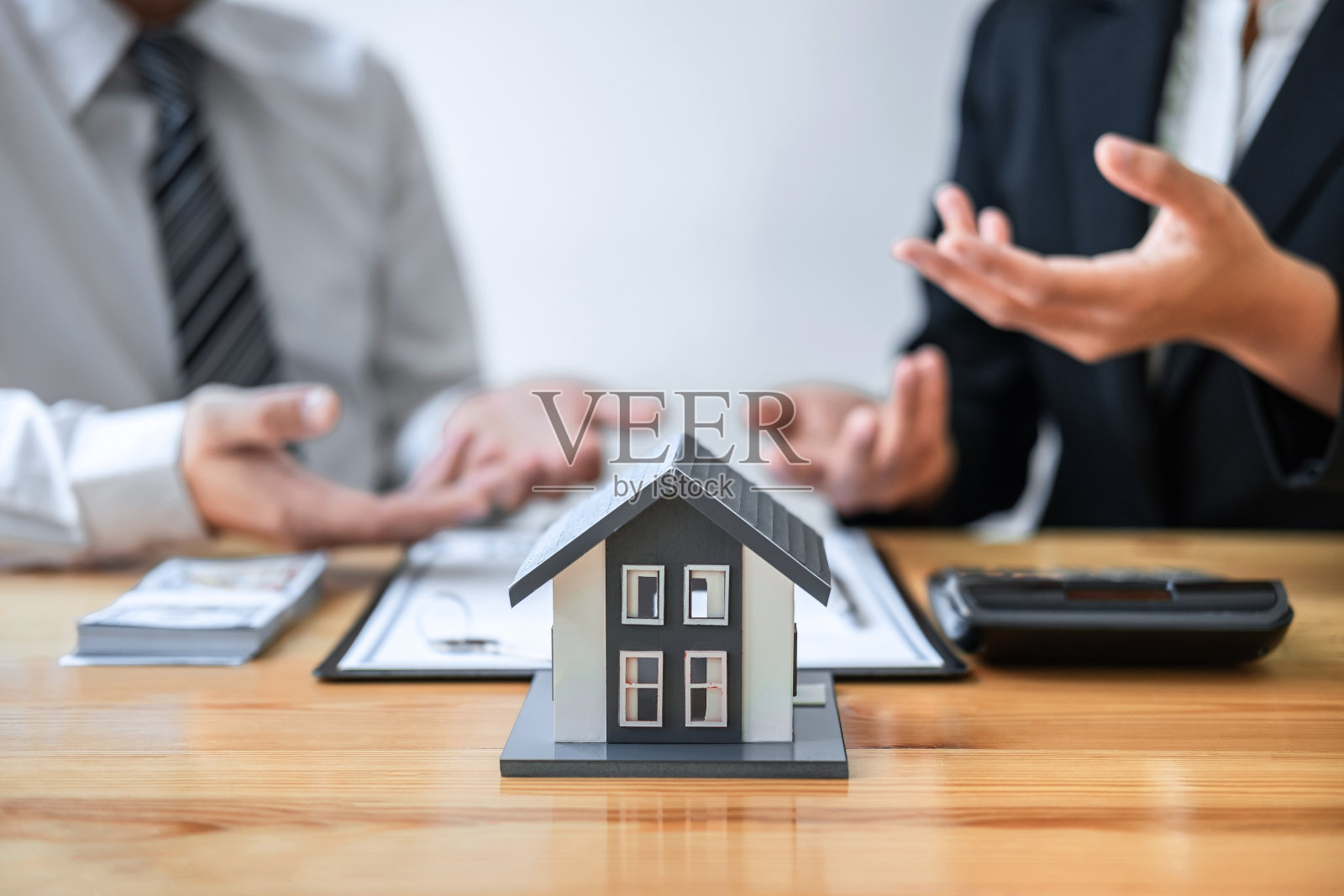 房地产经纪人在与客户讨论并签署批准的申请表、住房保险和房地产投资概念的协议合同后,向客户提供住房贷款和房屋照片摄影图片