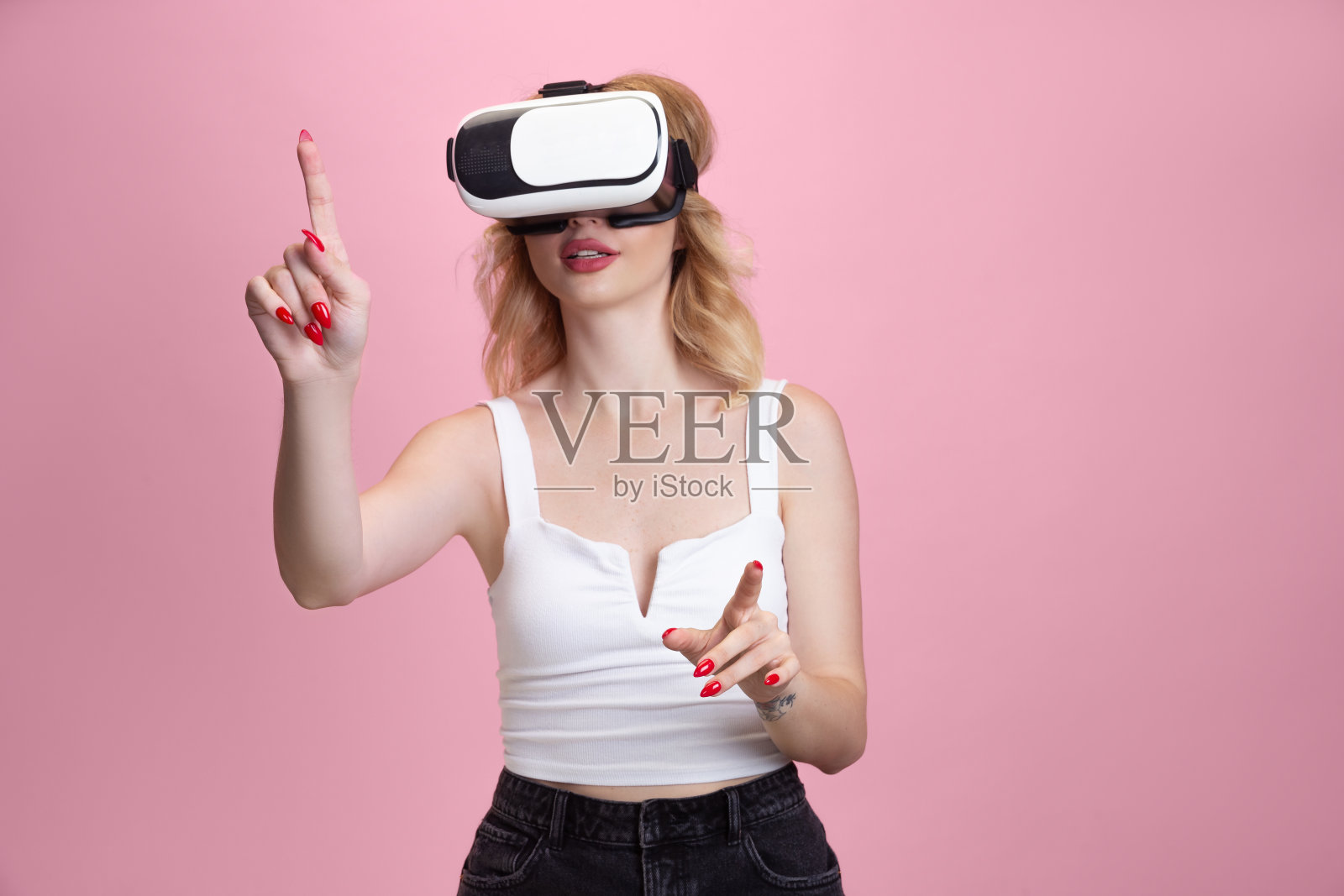 一个白人年轻女子的肖像被隔离在粉红色的画室背景上。漂亮的女模特。人类情感的概念,面部表情,销售,广告,青年文化。照片摄影图片