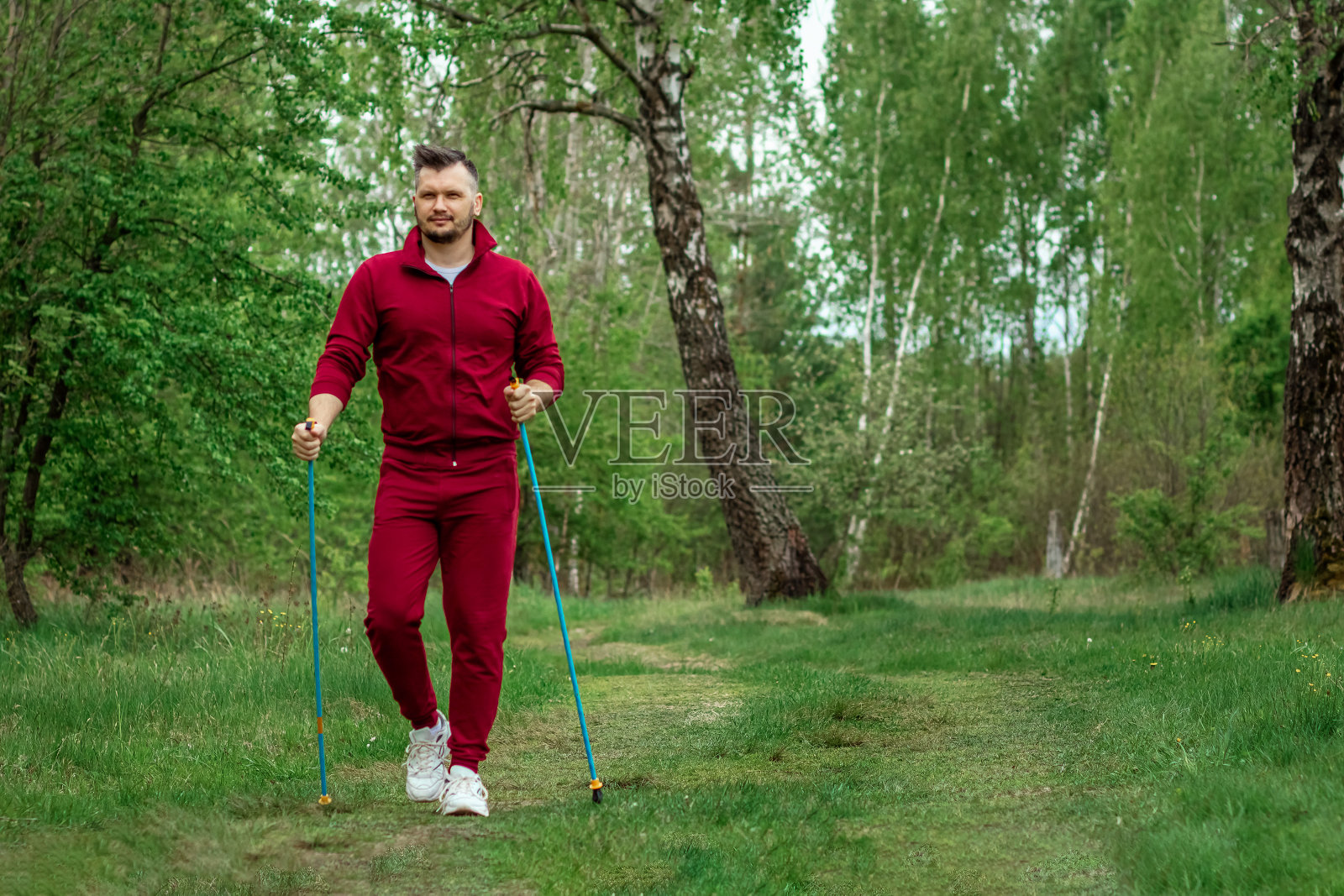 一名穿着运动服的男子正在进行北欧式步行。健康的生活方式,有氧运动的概念。Copyspace。照片摄影图片