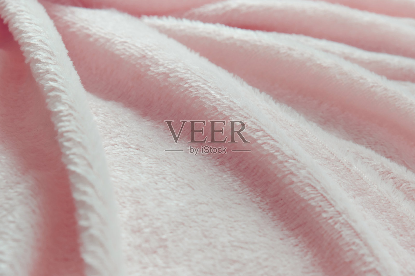 精致柔软的背景毛绒织物折叠在白色的背景。副本的空间。平的。淡紫色人造毛皮面料上的宽松褶皱。暖冬衣服的细节照片摄影图片