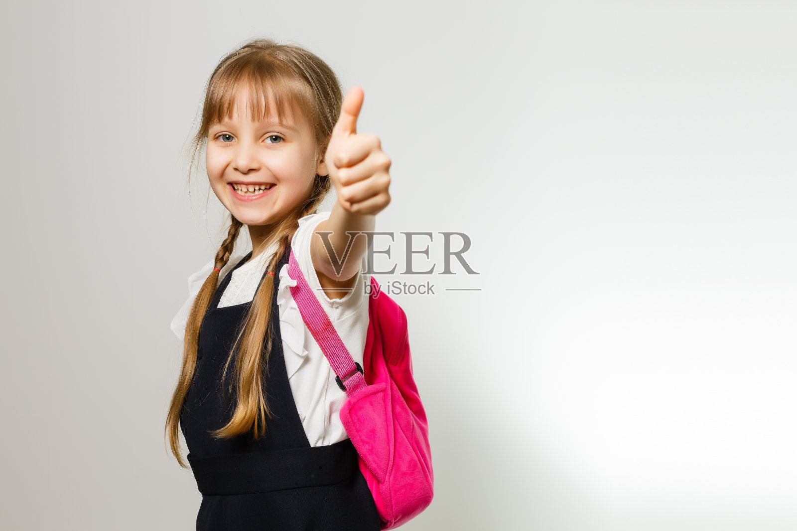 可爱的微笑的校服女生站在白色的背景照片摄影图片