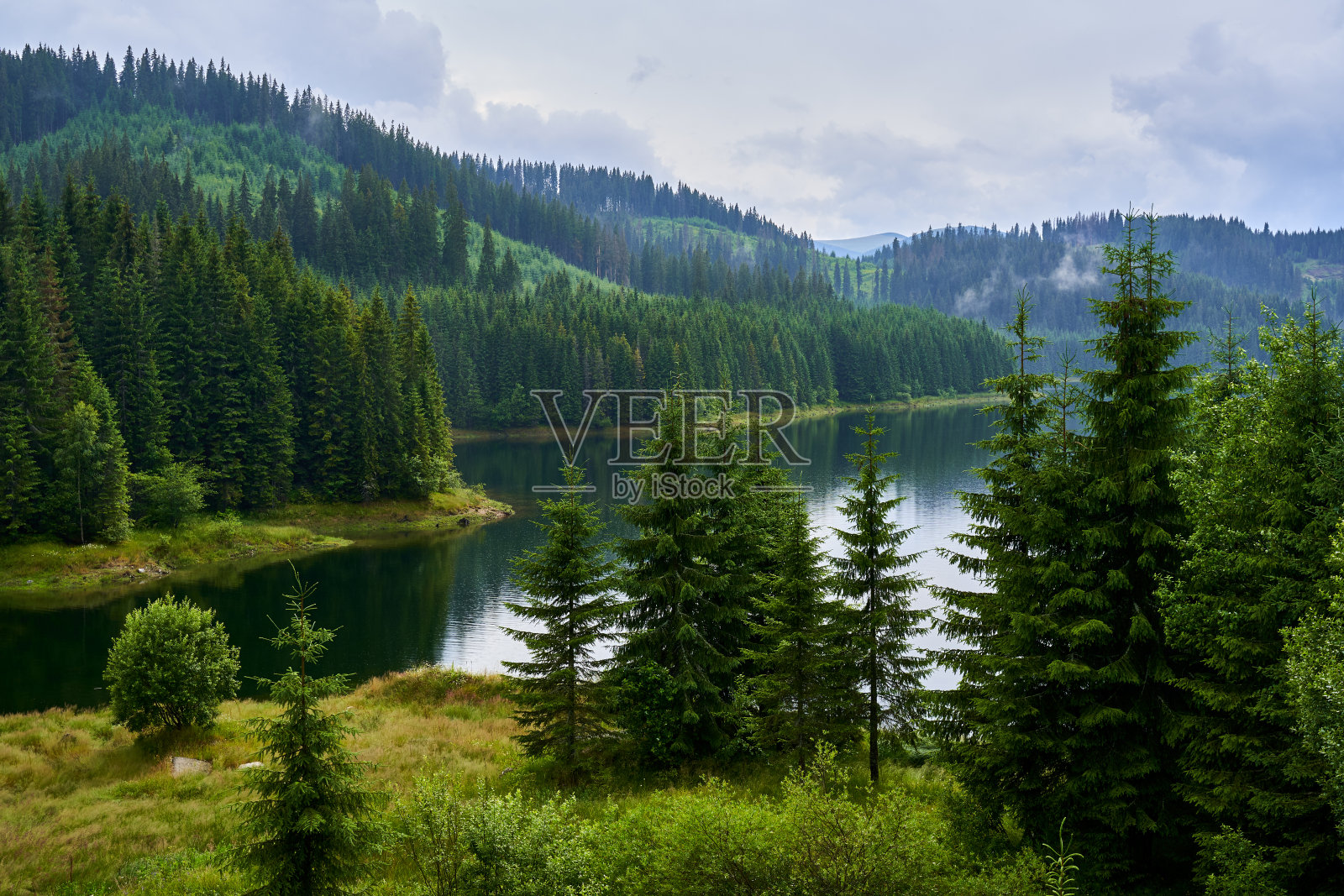 在一个有雾的日子里山上的一个湖照片摄影图片