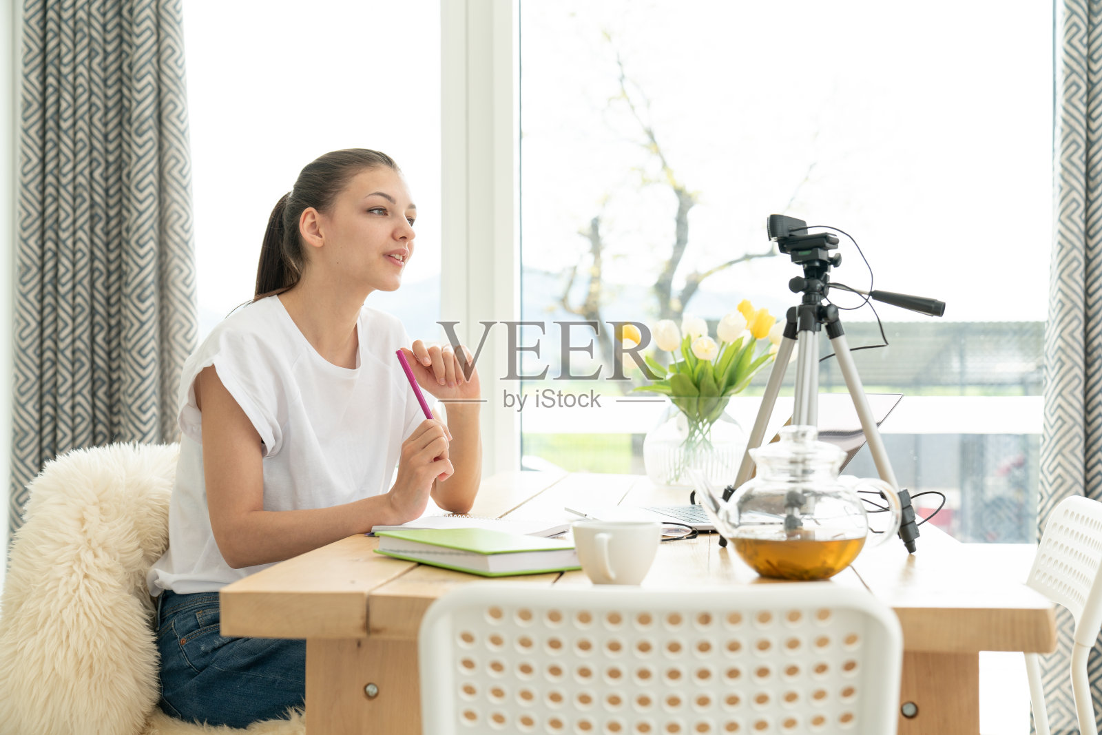 一个年轻女孩的博主和你的订阅者谈论。在社交网络上录制视频博客的女子照片摄影图片