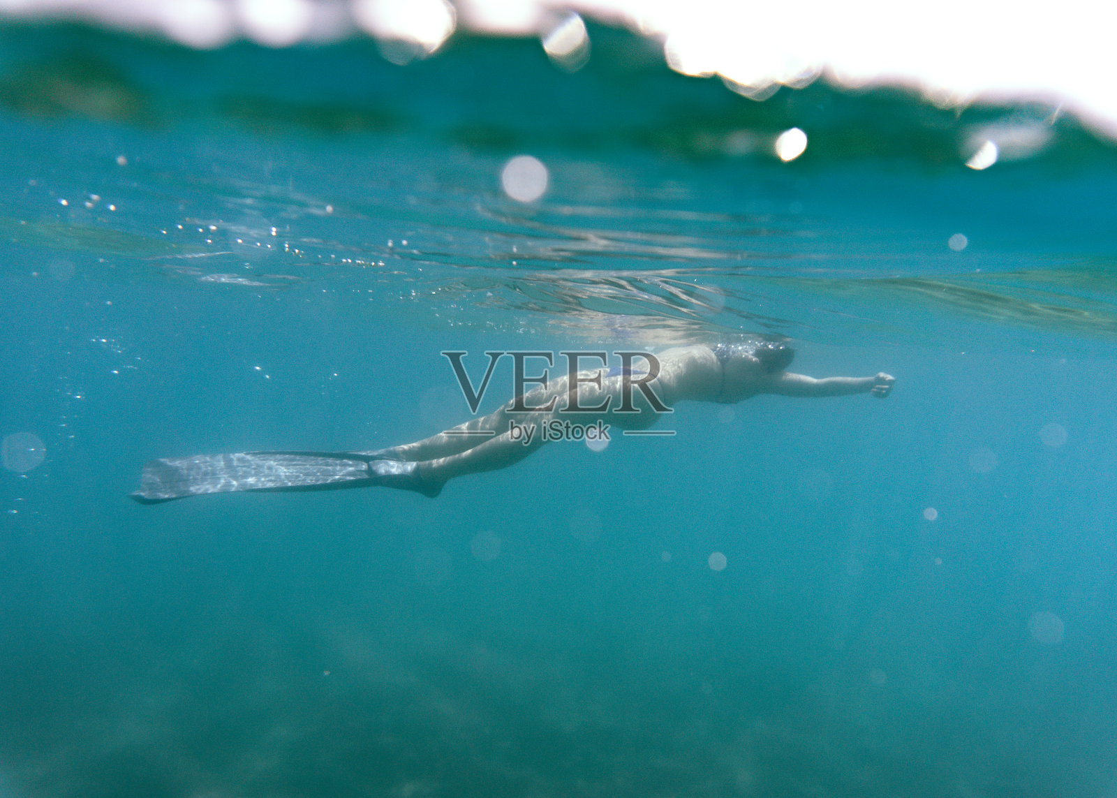 年轻女子在海里浮潜。照片摄影图片