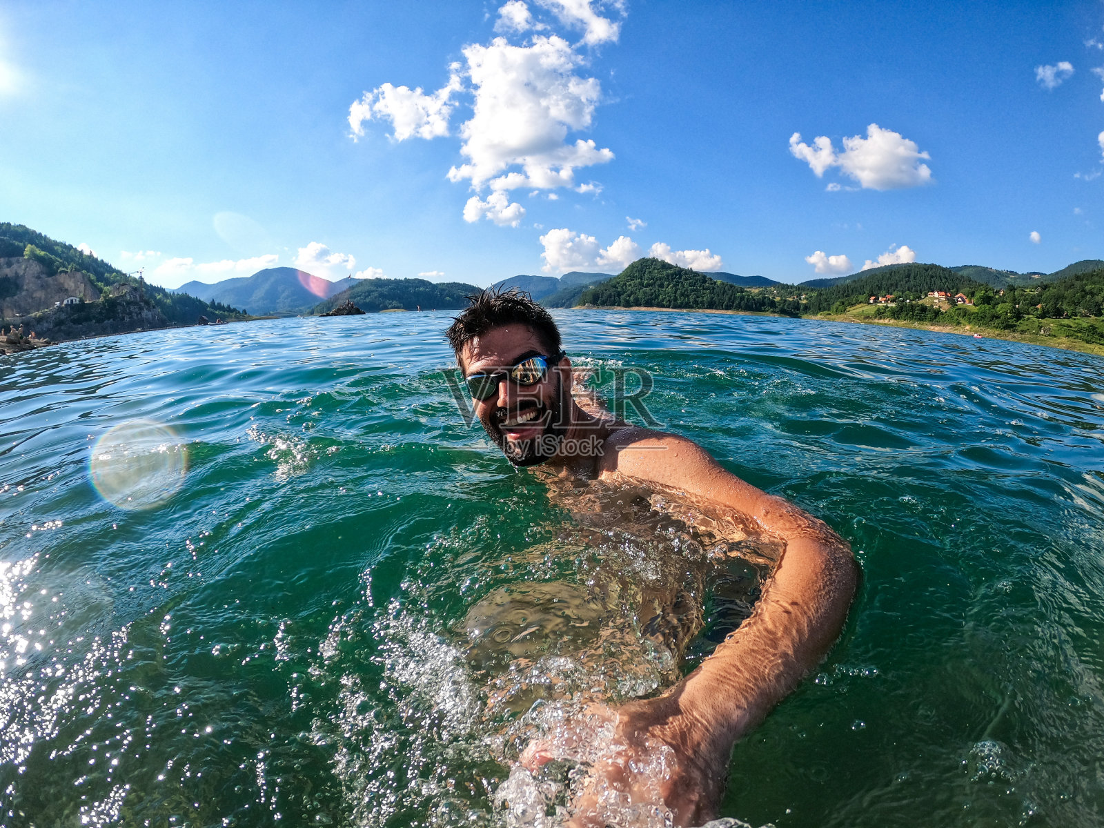 一个快乐的人在炎热的夏天在海里游泳,过着健康的生活方式照片摄影图片