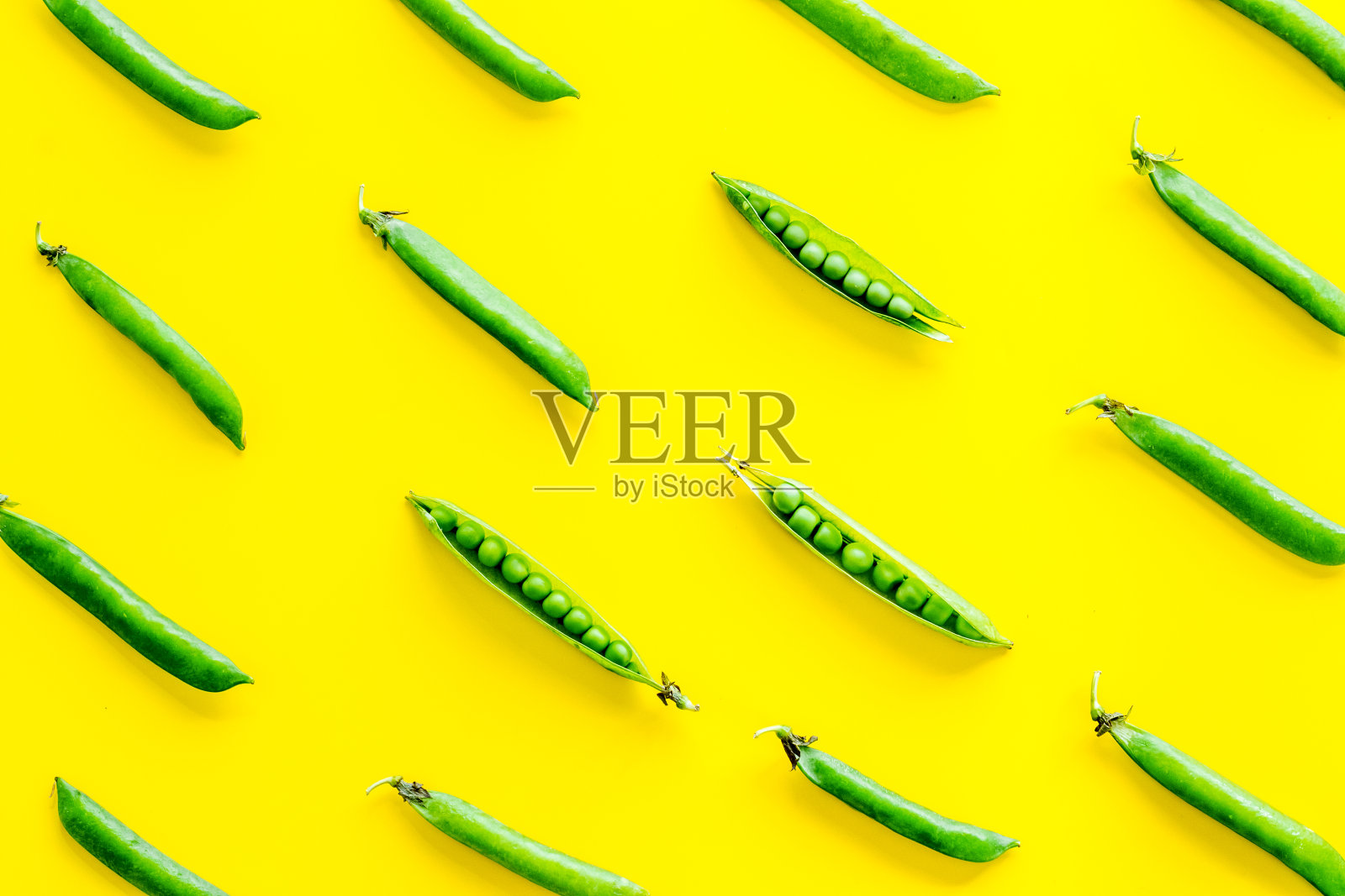 厨房桌上新鲜的绿色豌豆荚和豆子的图案。俯视图照片摄影图片