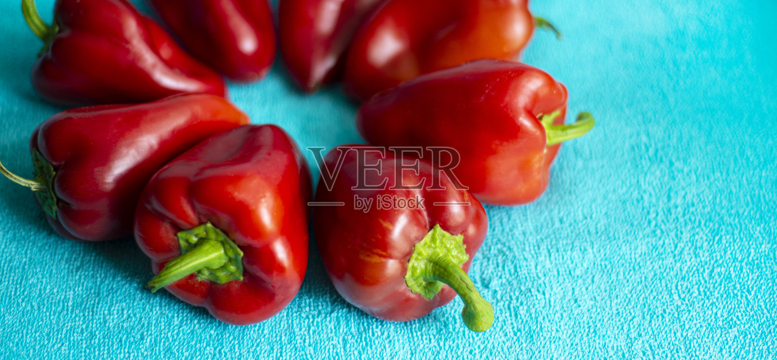 蓝色背景上的红灯笼椒。明亮的蔬菜。照片摄影图片