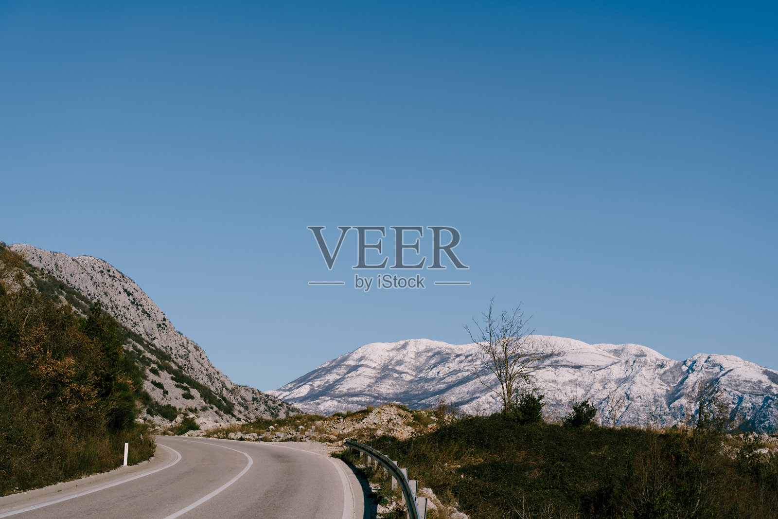 蜿蜒的山路,蓝天下的山景。照片摄影图片