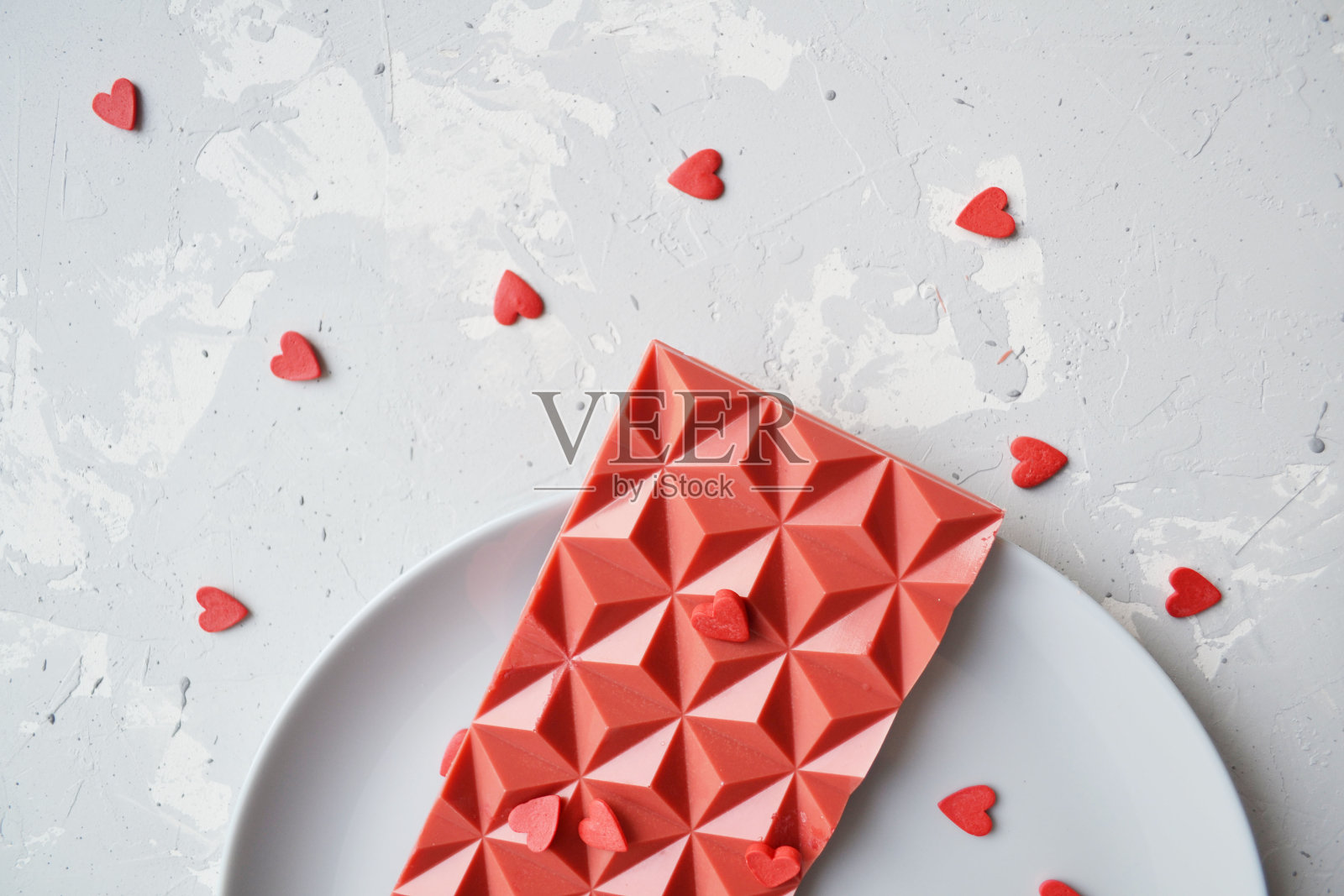 白色背景盘子里的红色心形巧克力俯视图照片摄影图片