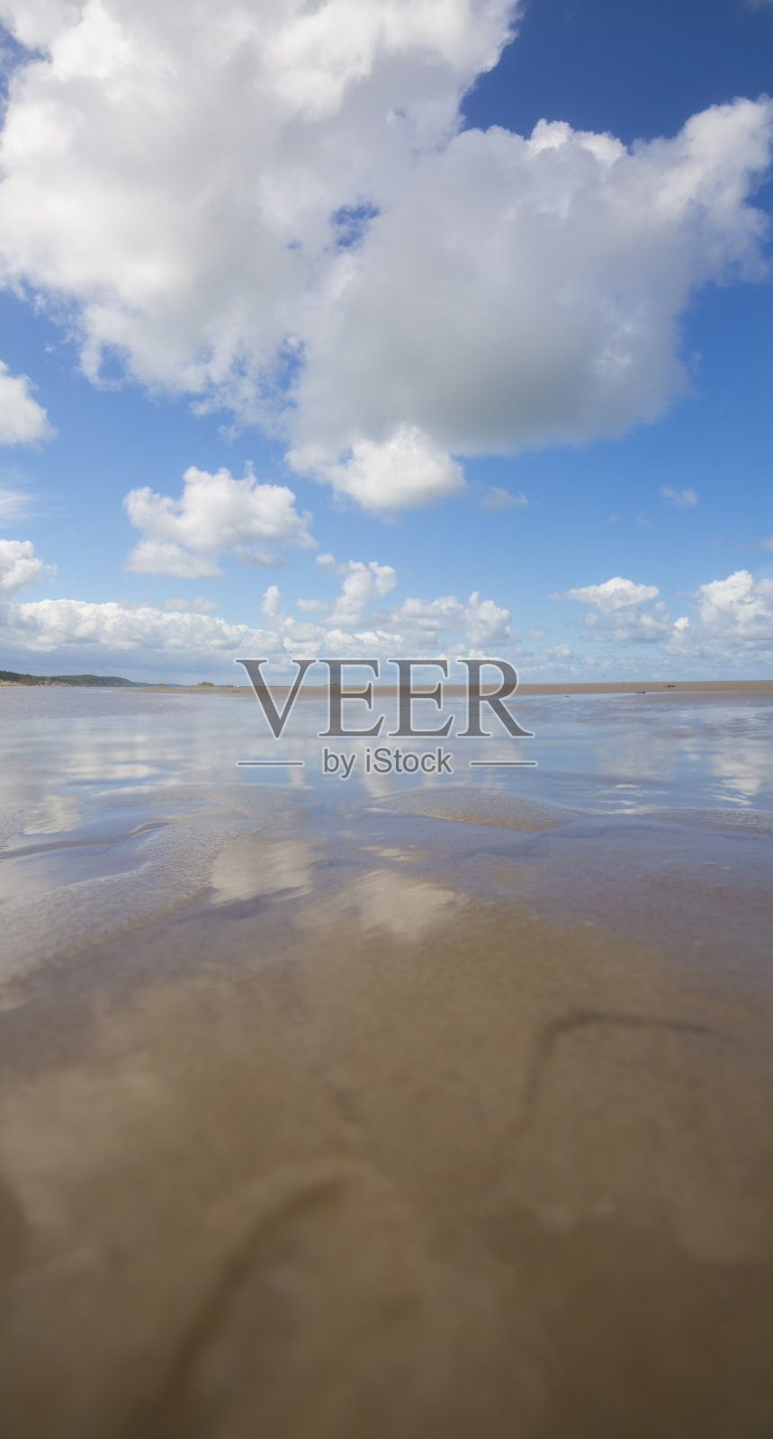 海滩上的日落。阳光明媚的海滩,蓝天白云。照片摄影图片