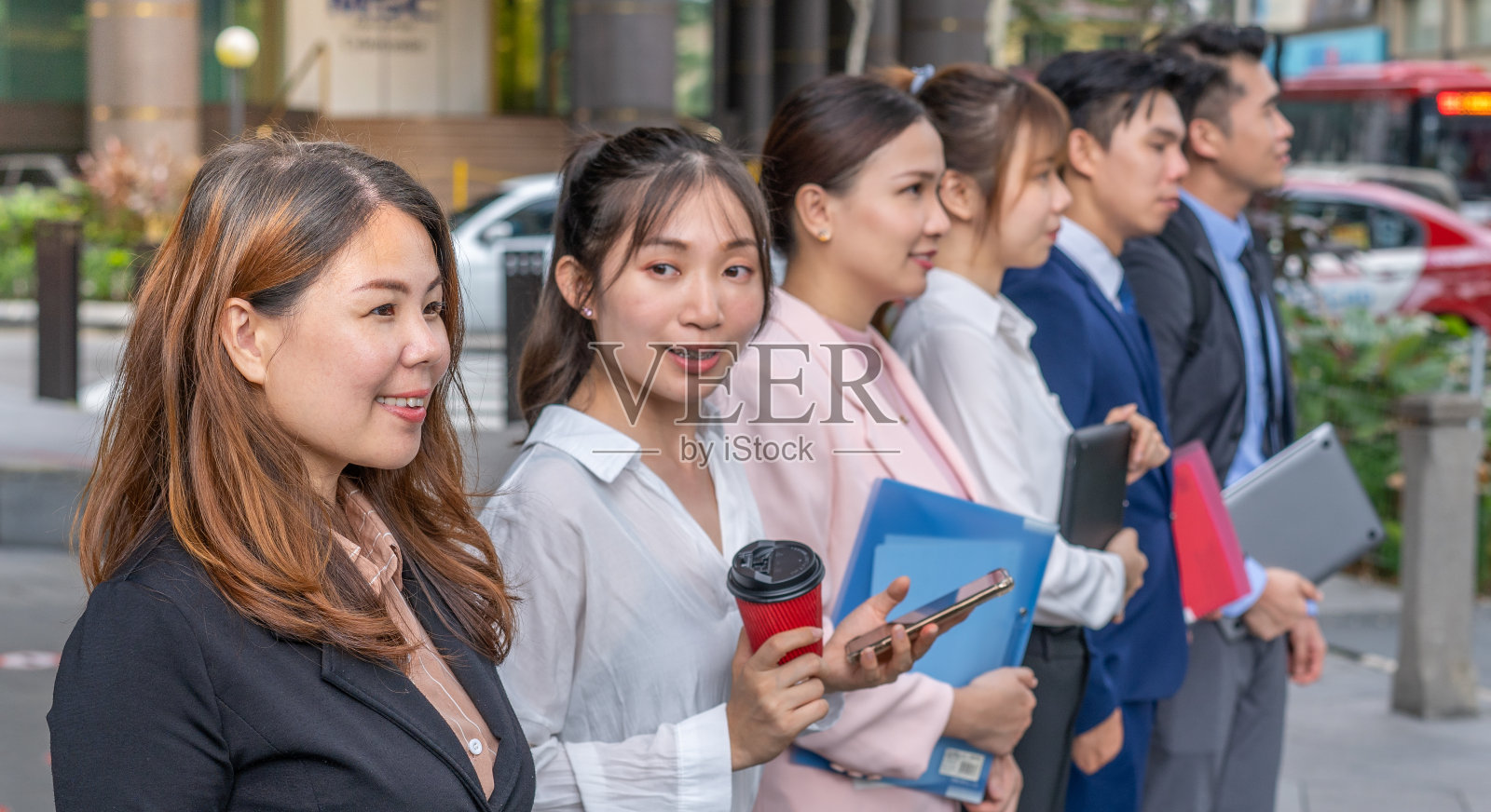 一群年轻的中国上班族在城市外面排队照片摄影图片