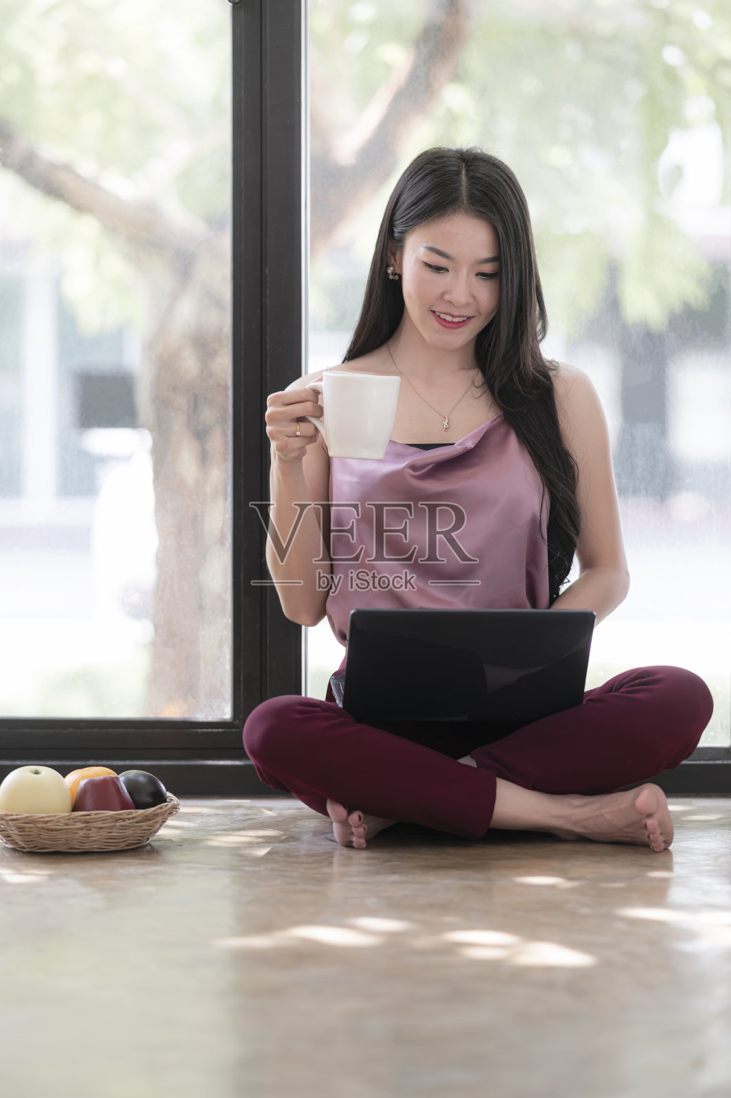 年轻的亚洲妇女工作与笔记本电脑在家里。照片摄影图片