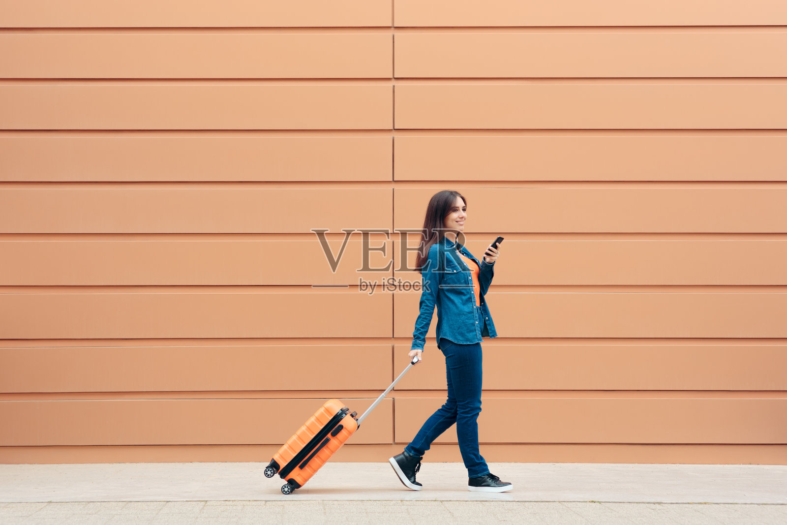 带着行李箱的旅行女性检查智能手机照片摄影图片