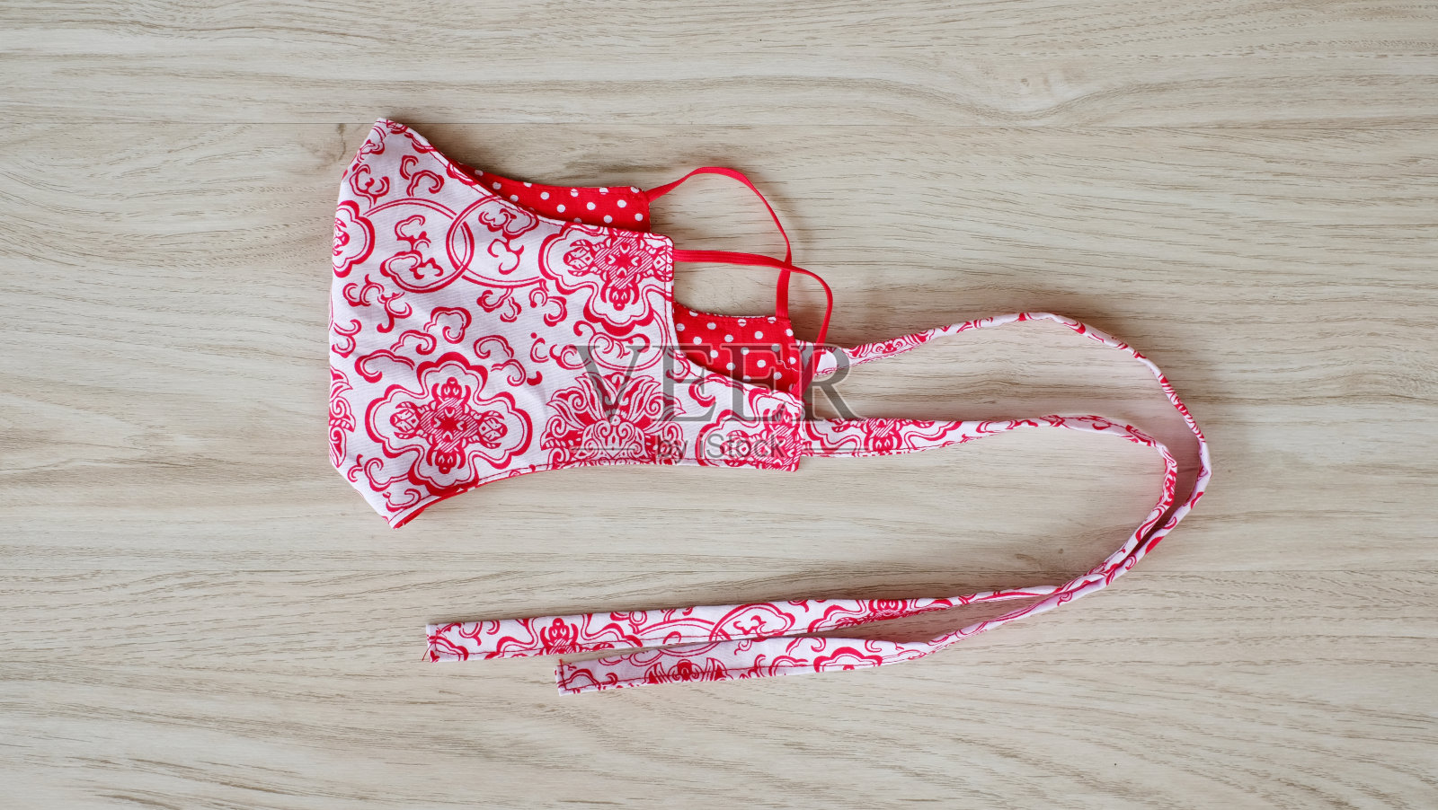 用纯棉手工织成的手织面膜,上面有美丽的花朵图案。卫生口罩,以覆盖嘴和保护与时尚的缝纫时尚。照片摄影图片