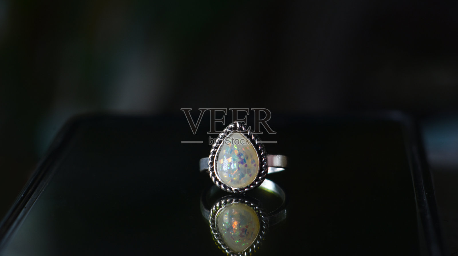 欧泊是一枚饰有欧泊宝石的银戒指。照片摄影图片