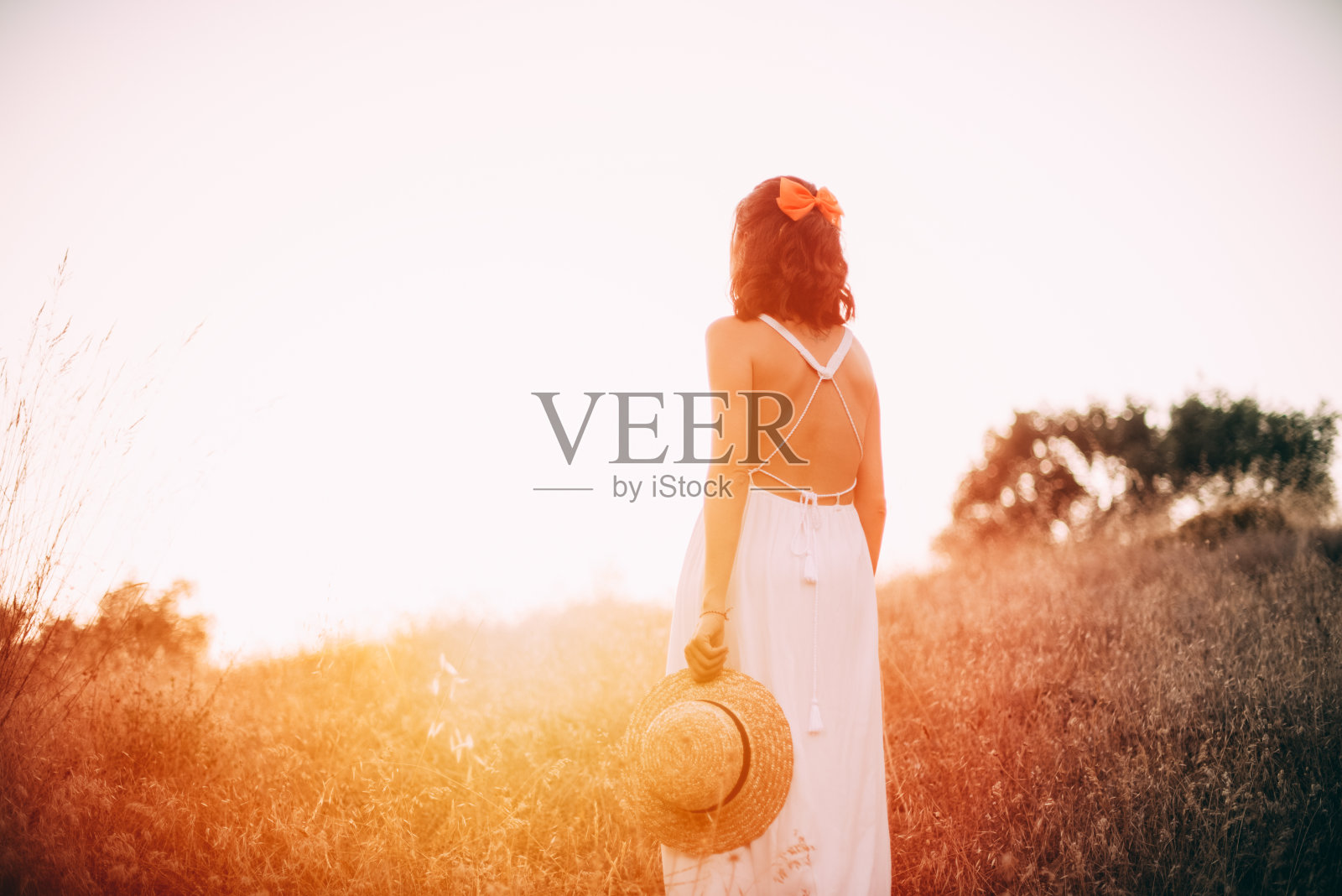 日落时草地上的女人照片摄影图片