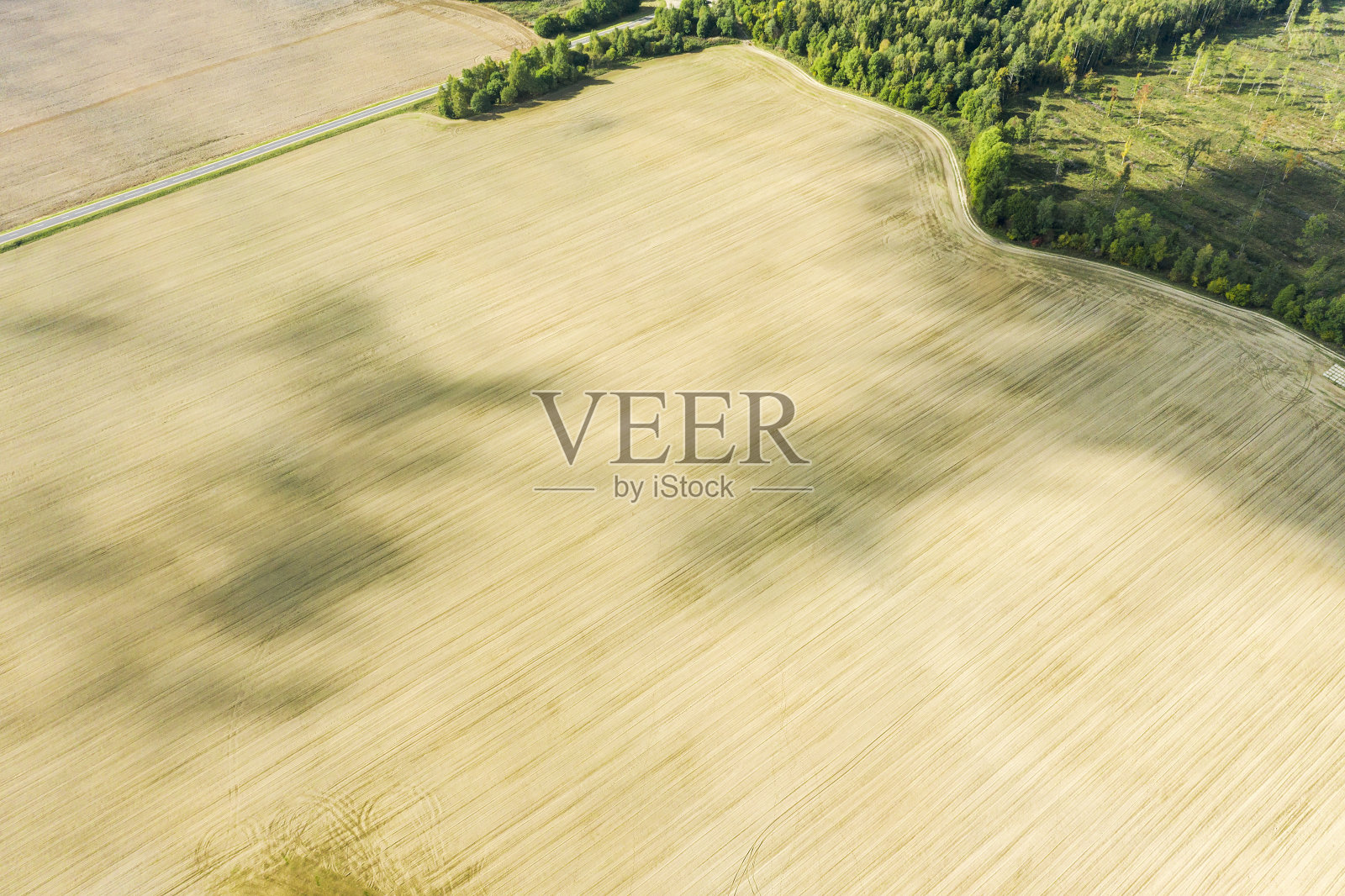 鸟瞰图犁地在明亮的夏日与阴影从云照片摄影图片