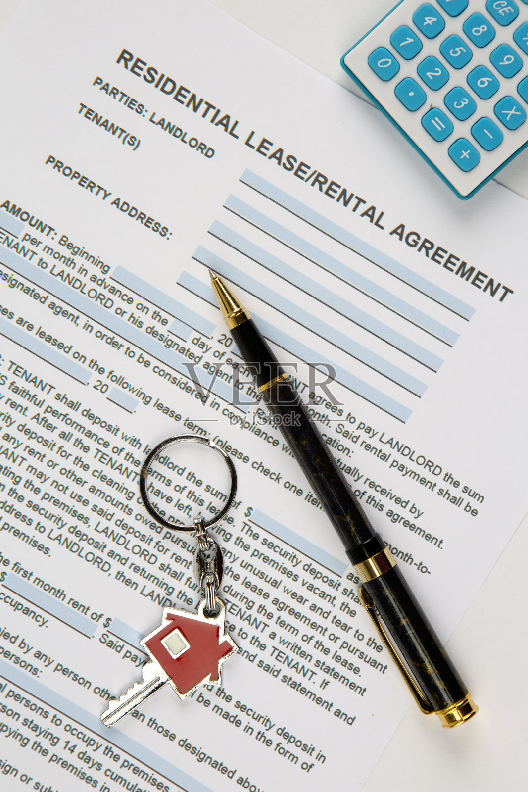 房屋钥匙、钢笔、计算器等租赁协议文件。照片摄影图片