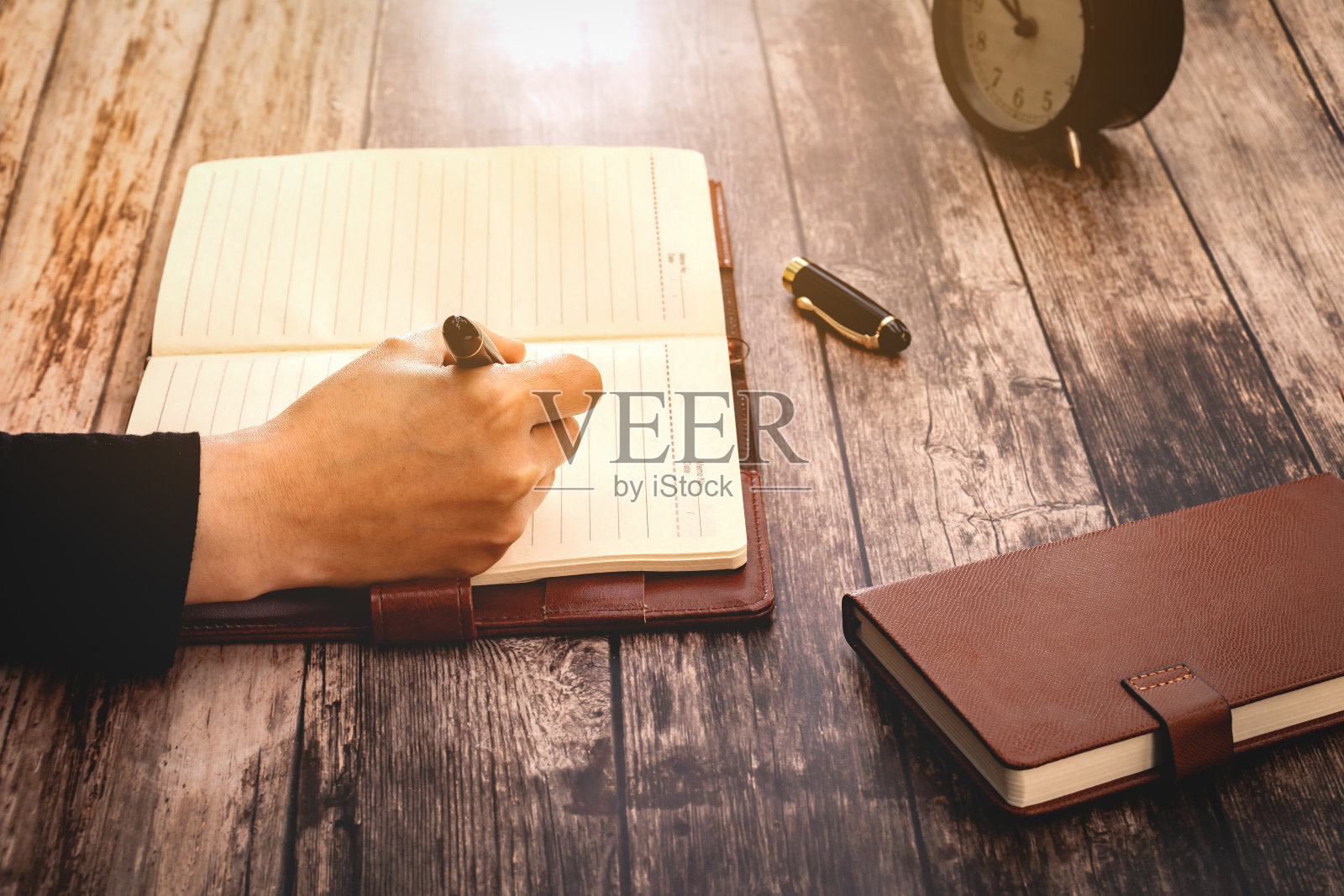 女人在木桌上写写画画。复古的过滤器照片摄影图片