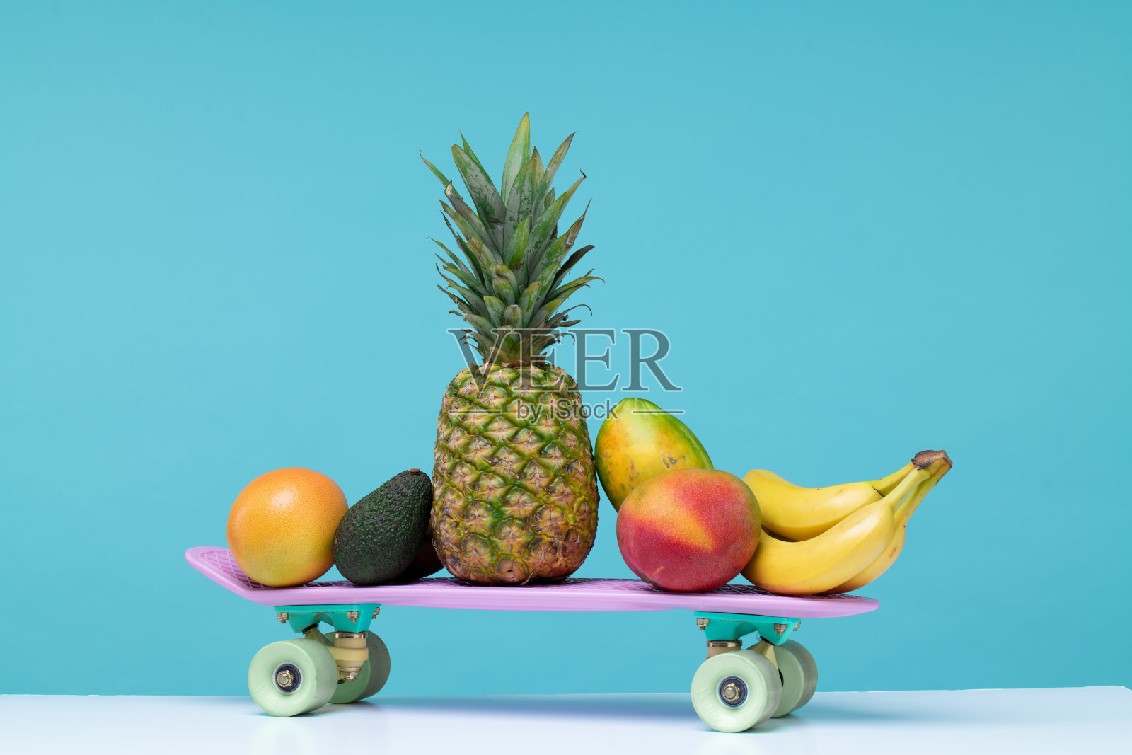 蓝色背景的水果站在滑板上照片摄影图片