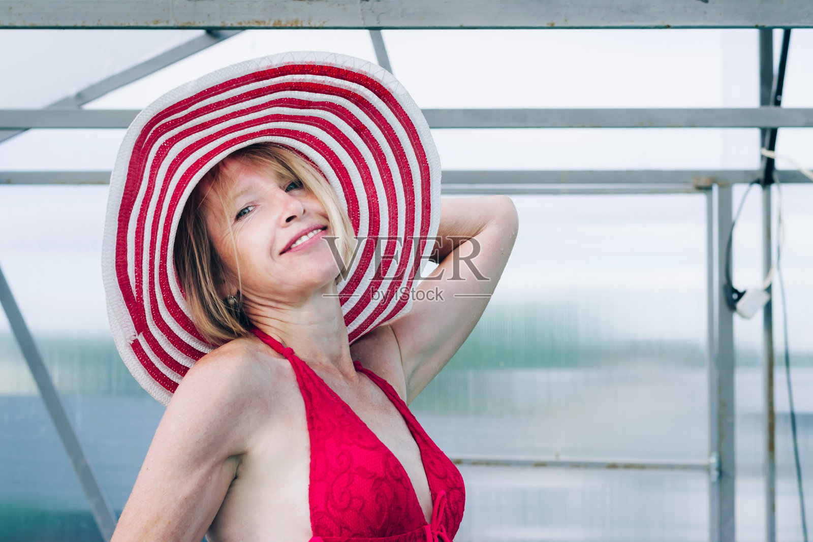 Cottagecore和Staycation在家。快乐的年老金发女人在泳衣和帽子。室内游泳池回家。孤立地放松照片摄影图片