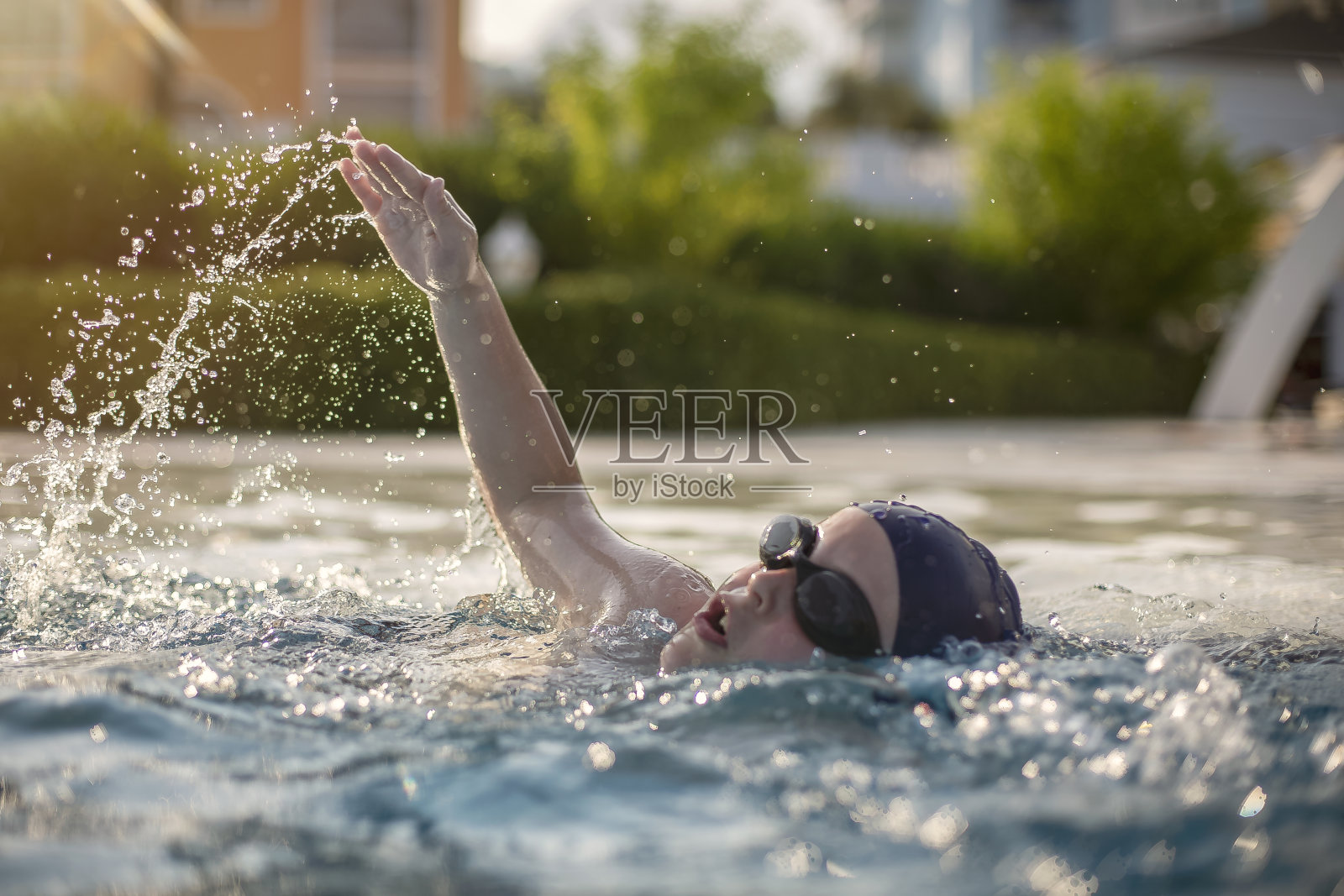 男孩在公共游泳池练习游泳照片摄影图片