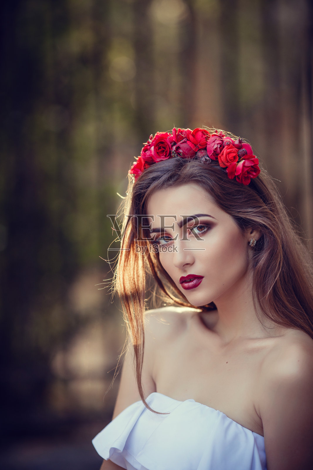 日落时在公园里戴着花环的漂亮的年轻褐发女人照片摄影图片