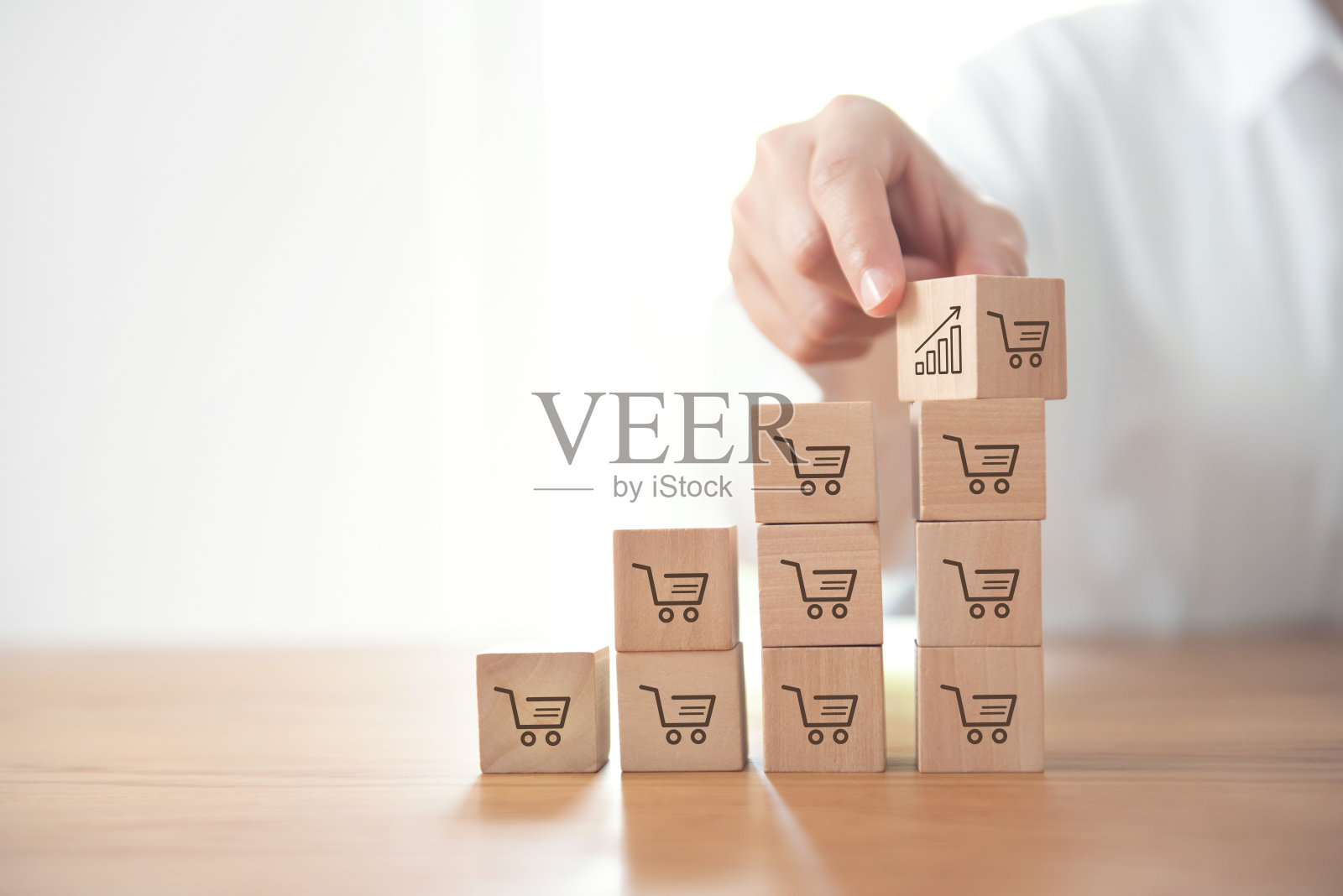 销售量的增加使业务增长,翻转立方体与图标图形和购物车符号。照片摄影图片