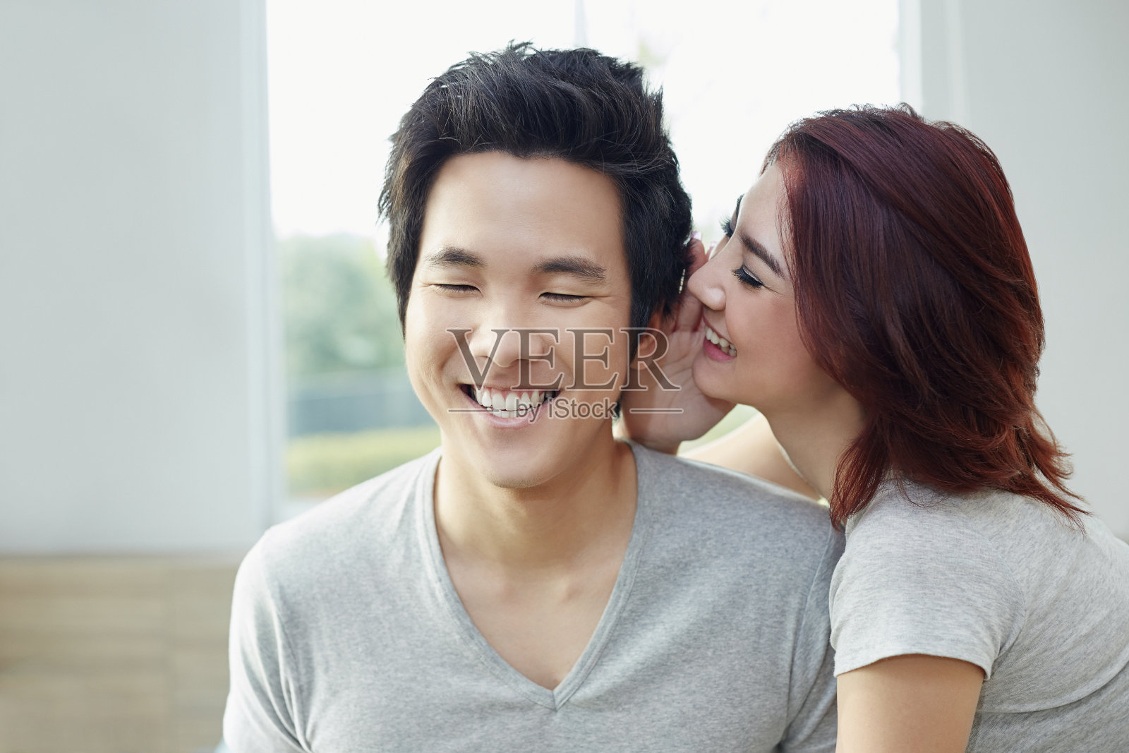 女朋友对男朋友耳语照片摄影图片