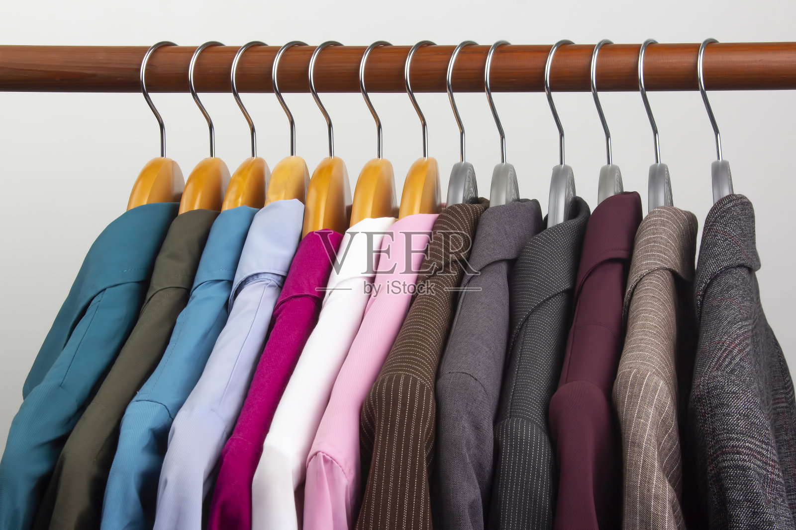 不同的女性办公室的经典夹克和衬衫可以挂在衣架上存放衣物。时尚服装款式的选择照片摄影图片