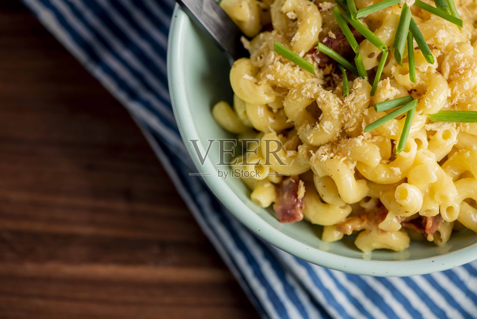 Mac n”奶酪。通心粉,意大利面和奶酪酱。帕尔马干酪,切达干酪和马苏里拉干酪,培根和意大利欧芹。经典美国或意大利餐厅的最爱。自制意大利面加酱汁,肉和奶酪。照片摄影图片