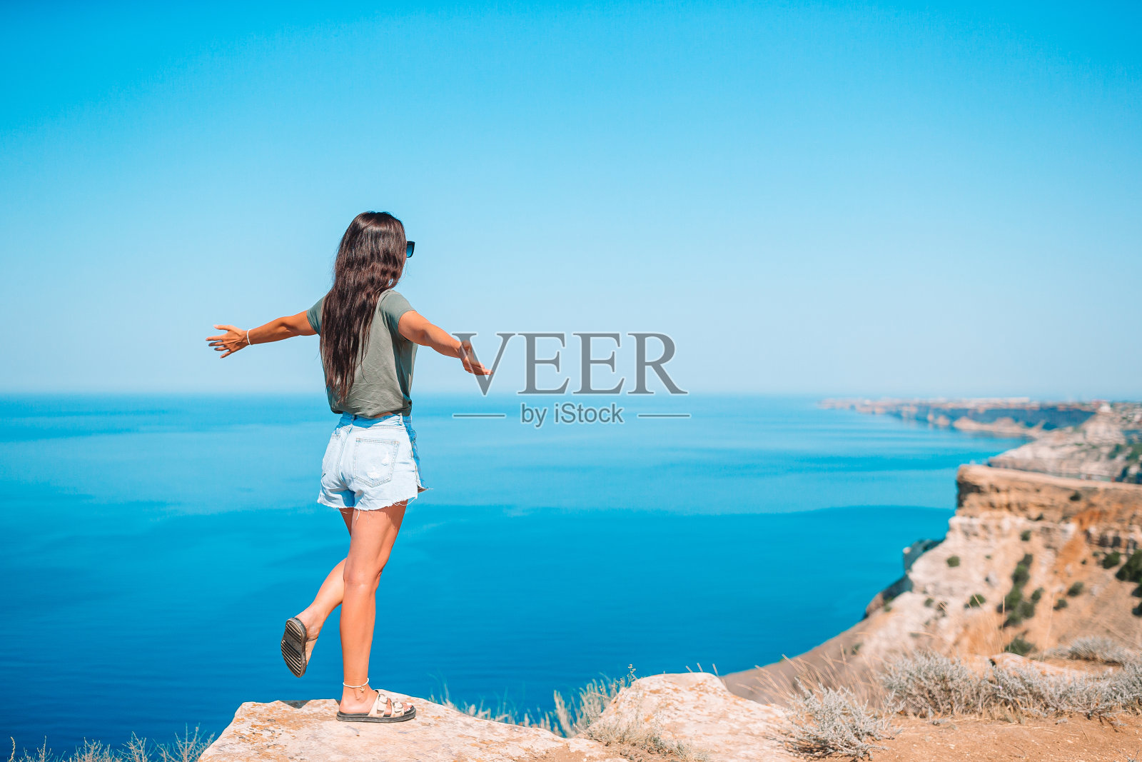 女游客在悬崖边的海边户外照片摄影图片