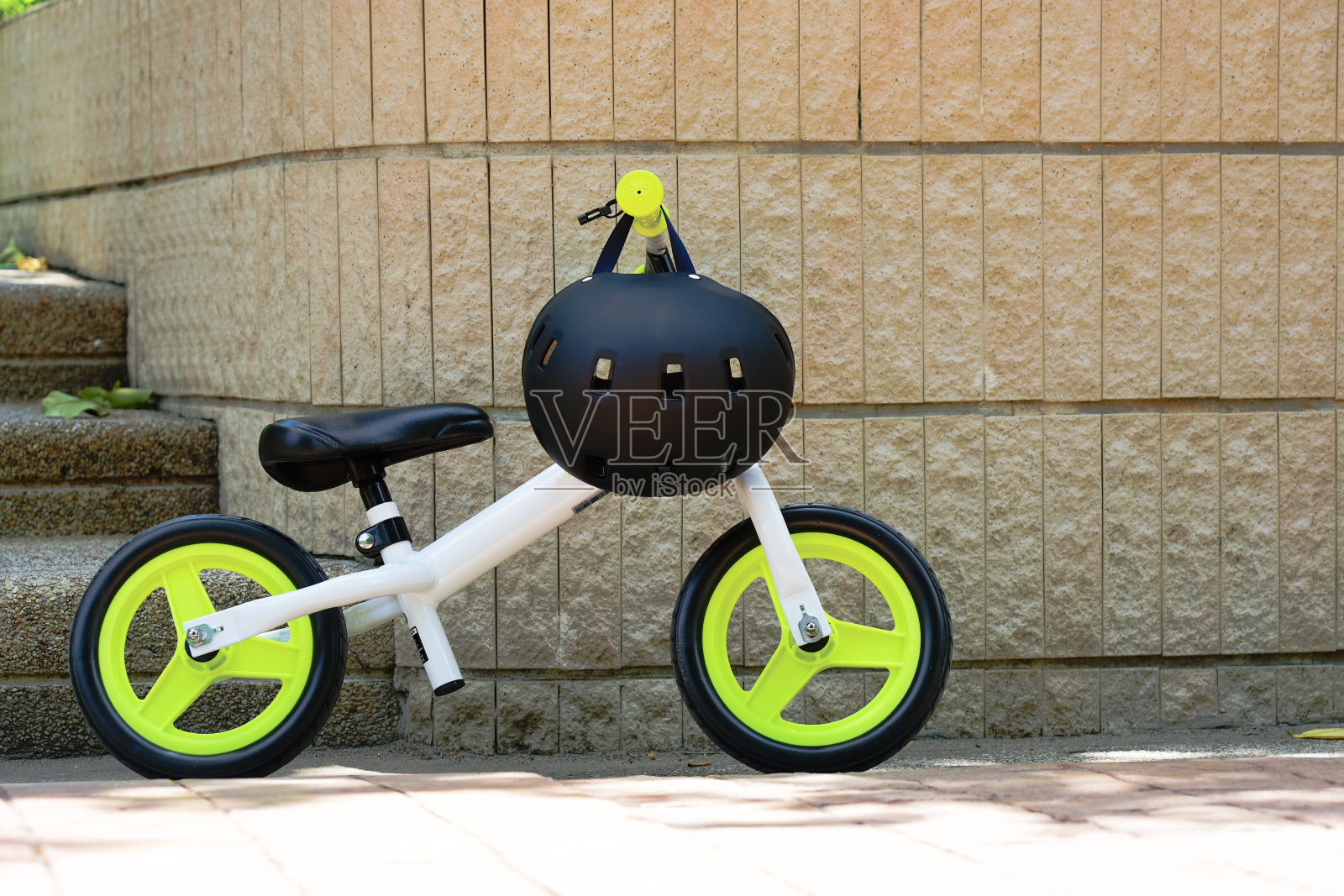 休闲活动时,骑自行车的孩子带着头盔停在公园里没人骑自行车照片摄影图片