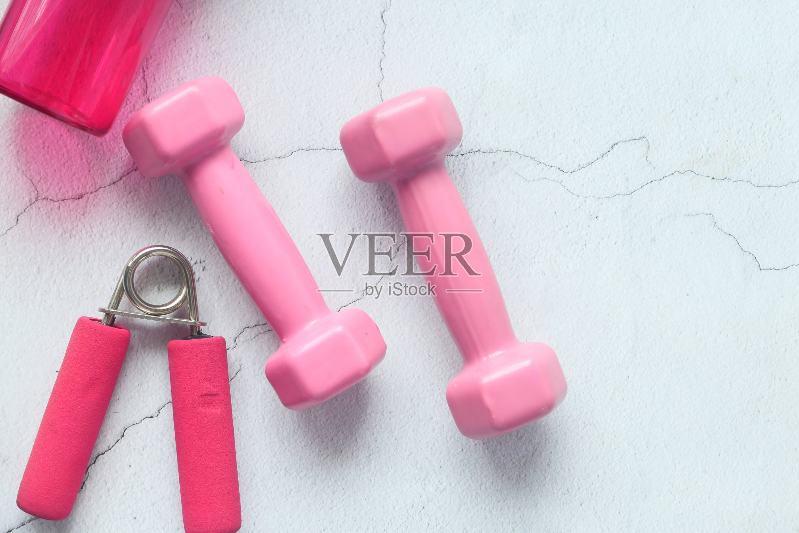 粉色哑铃,鞋子和瓶子上的白色背景照片摄影图片