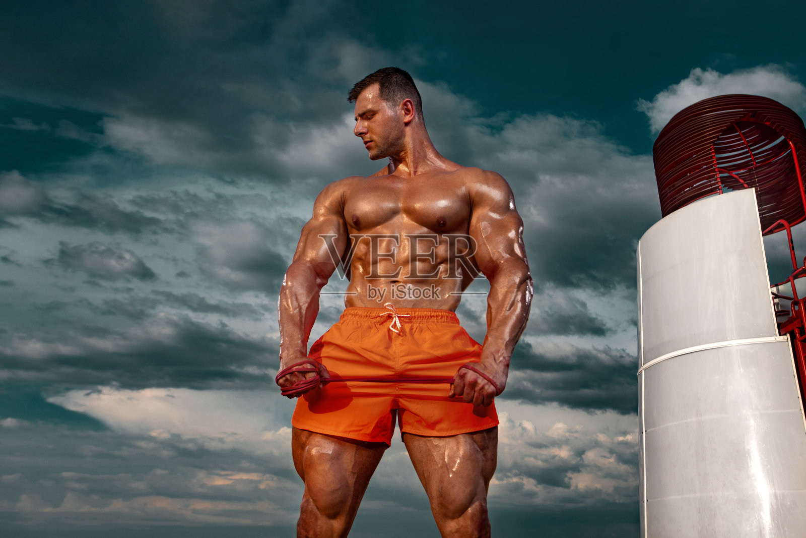 海滩上的健美运动员。迷人的年轻男子救生员附近的观察塔上的海滩。照片摄影图片