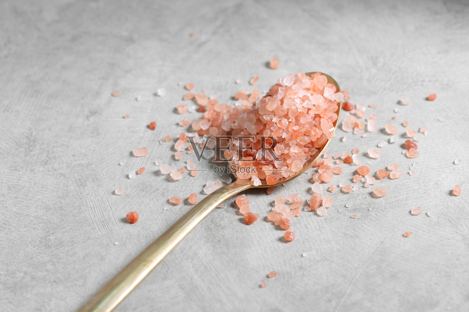 在阁楼背景上的金色勺子喜马拉雅粉盐照片摄影图片