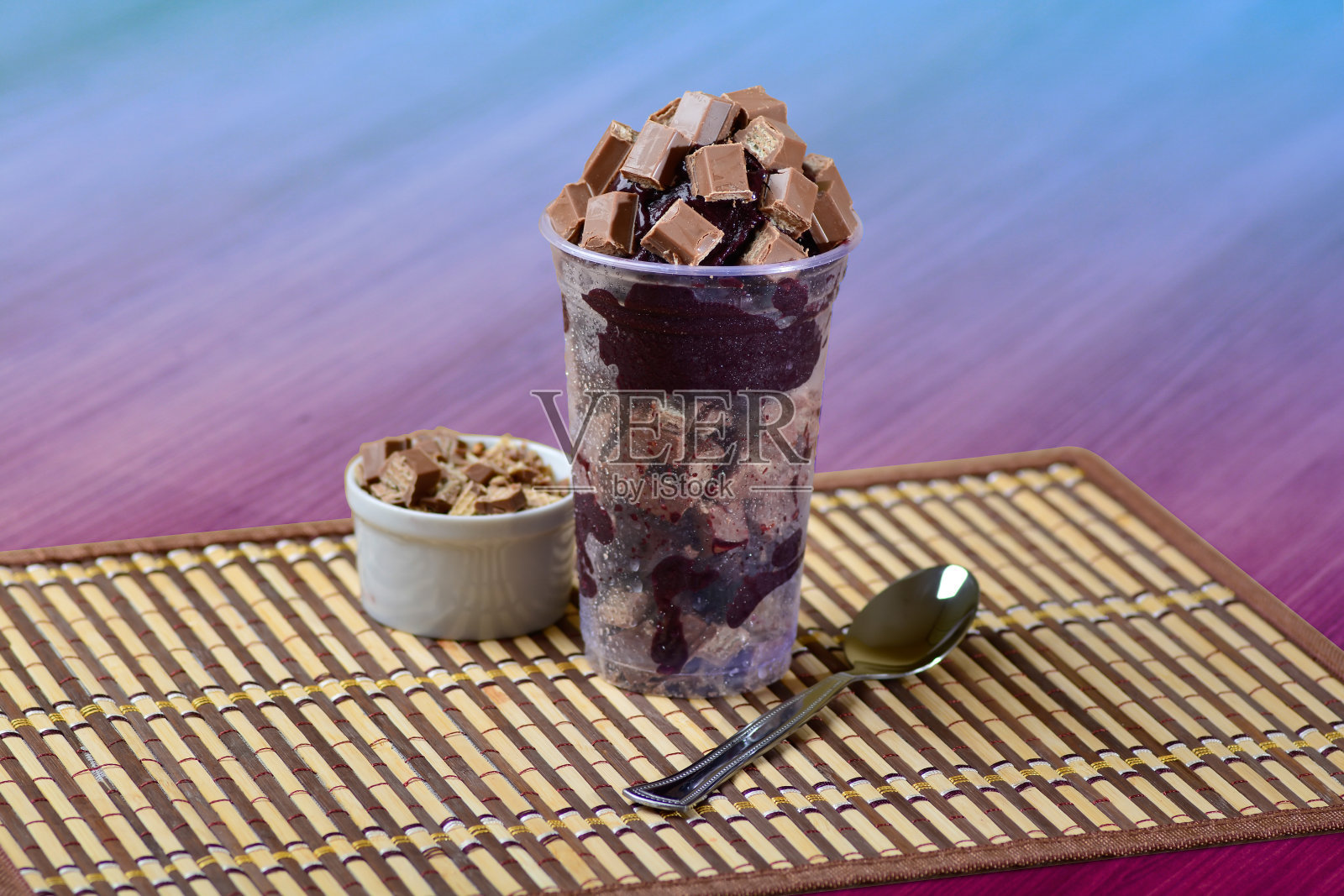 夏日巴西莓冰沙配巧克力。早餐巴西莓碗,装有巧克力和麦片的杯子放在木桌上照片摄影图片